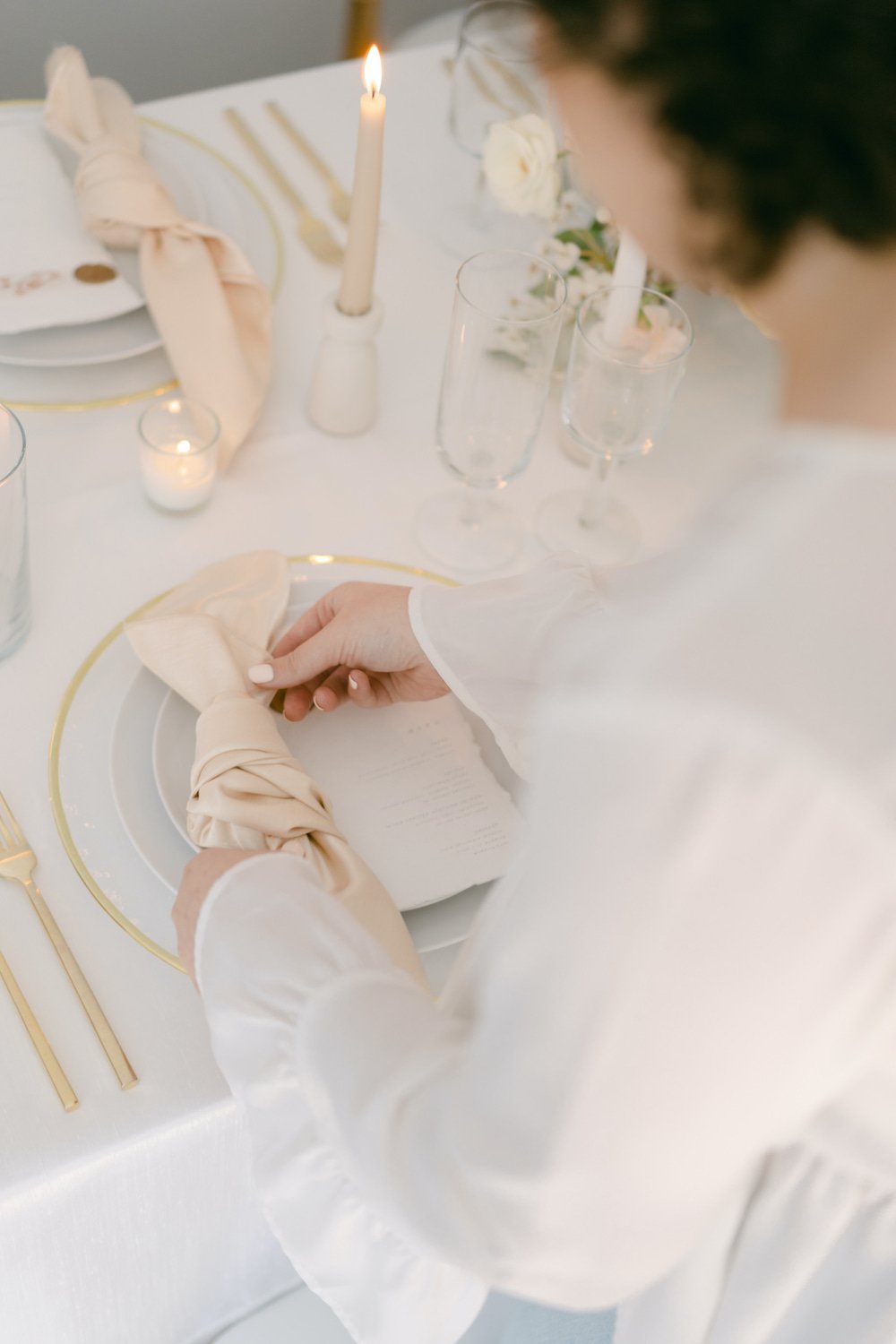 Wedding planner adjusting tied table napkins for the reception