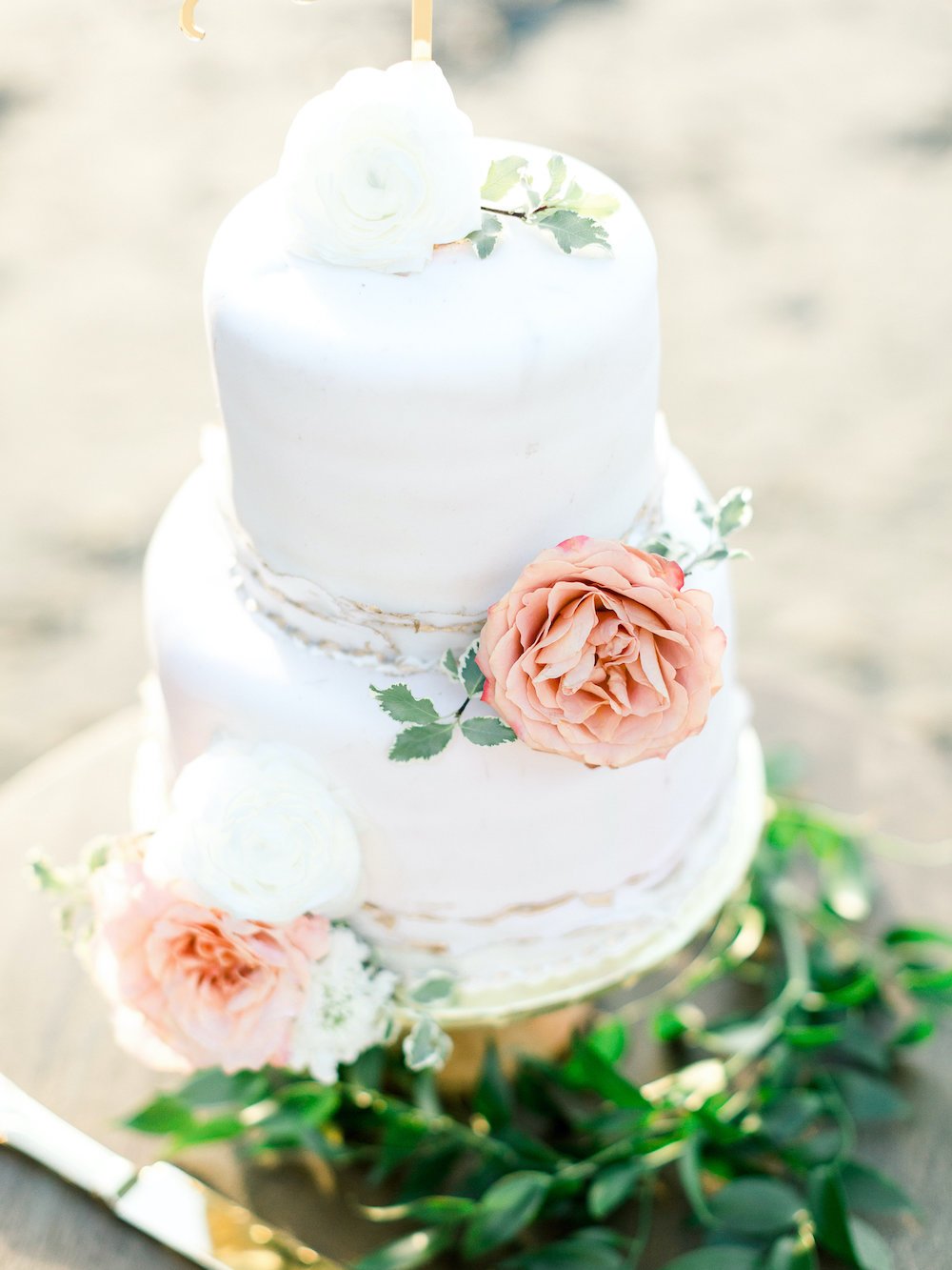 2-tier white fondant wedding cake with flowers.
