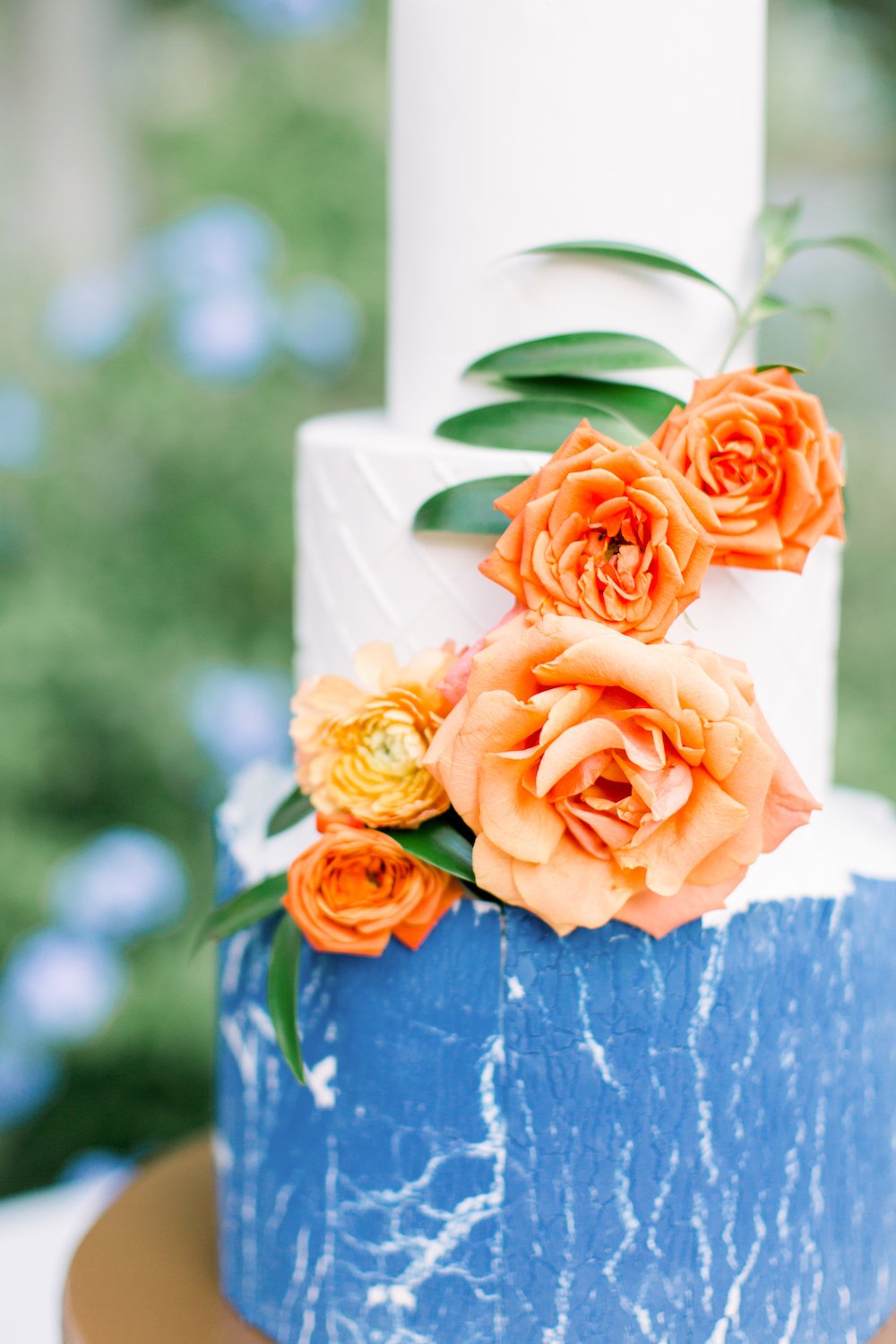 3-ter textured fondant wedding cake with orange flowers.