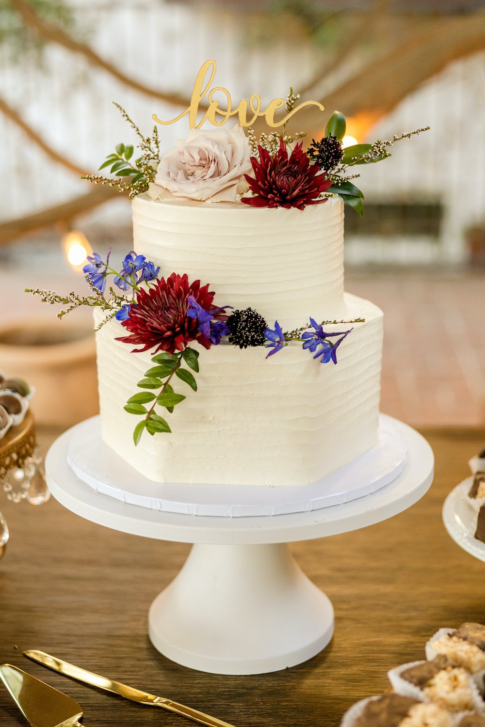 2-tier white hexagon buttercream wedding cake with flowers.