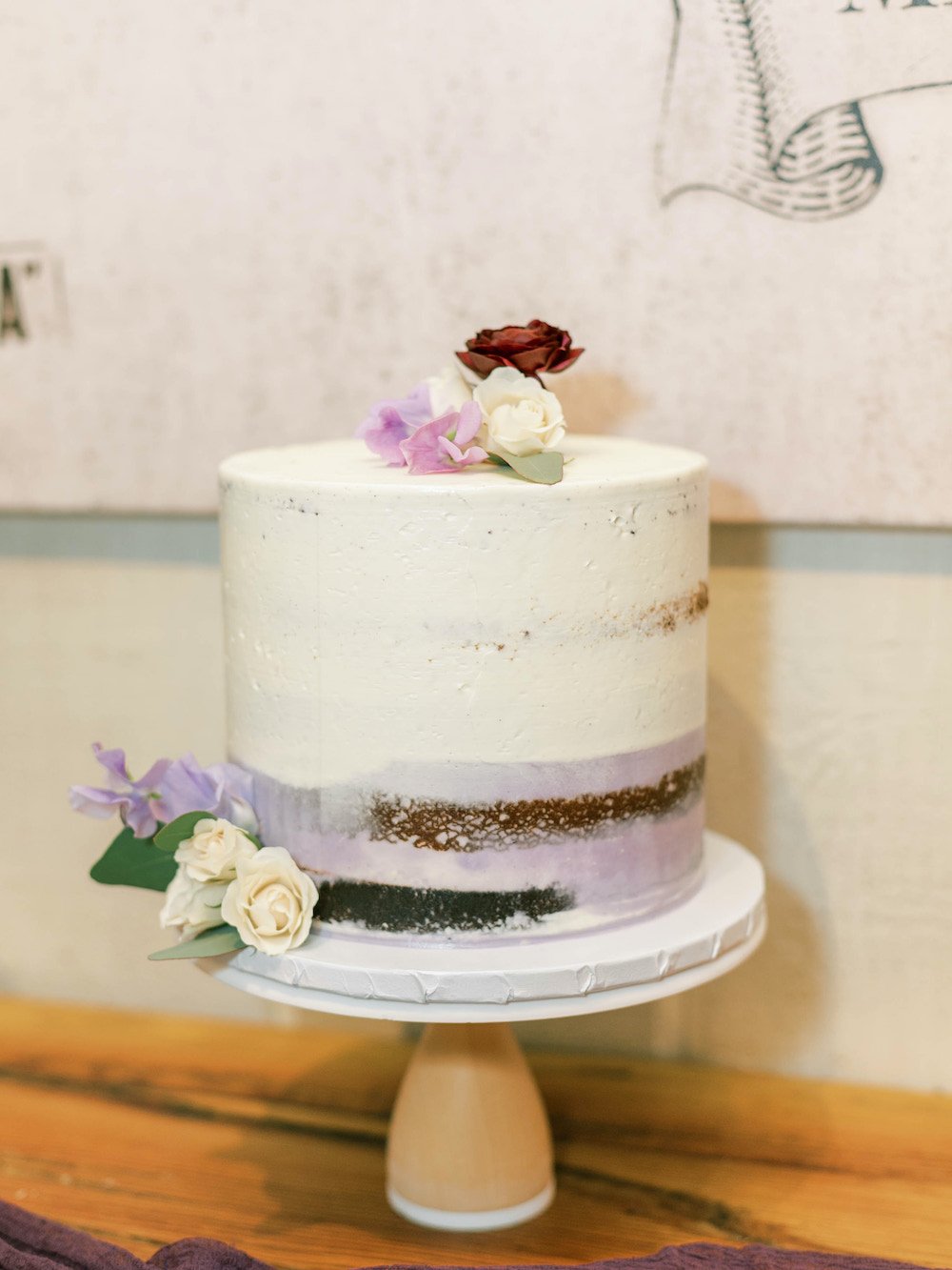 Simple purple semi-naked cake with flowers.