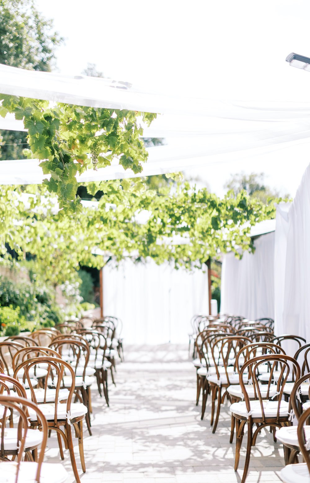Outdoor wedding ceremony with draping and floral decor.
