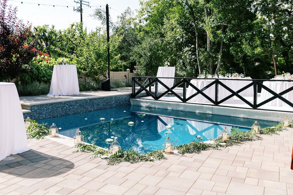 Private residence backyard wedding cocktail hour with a pool.