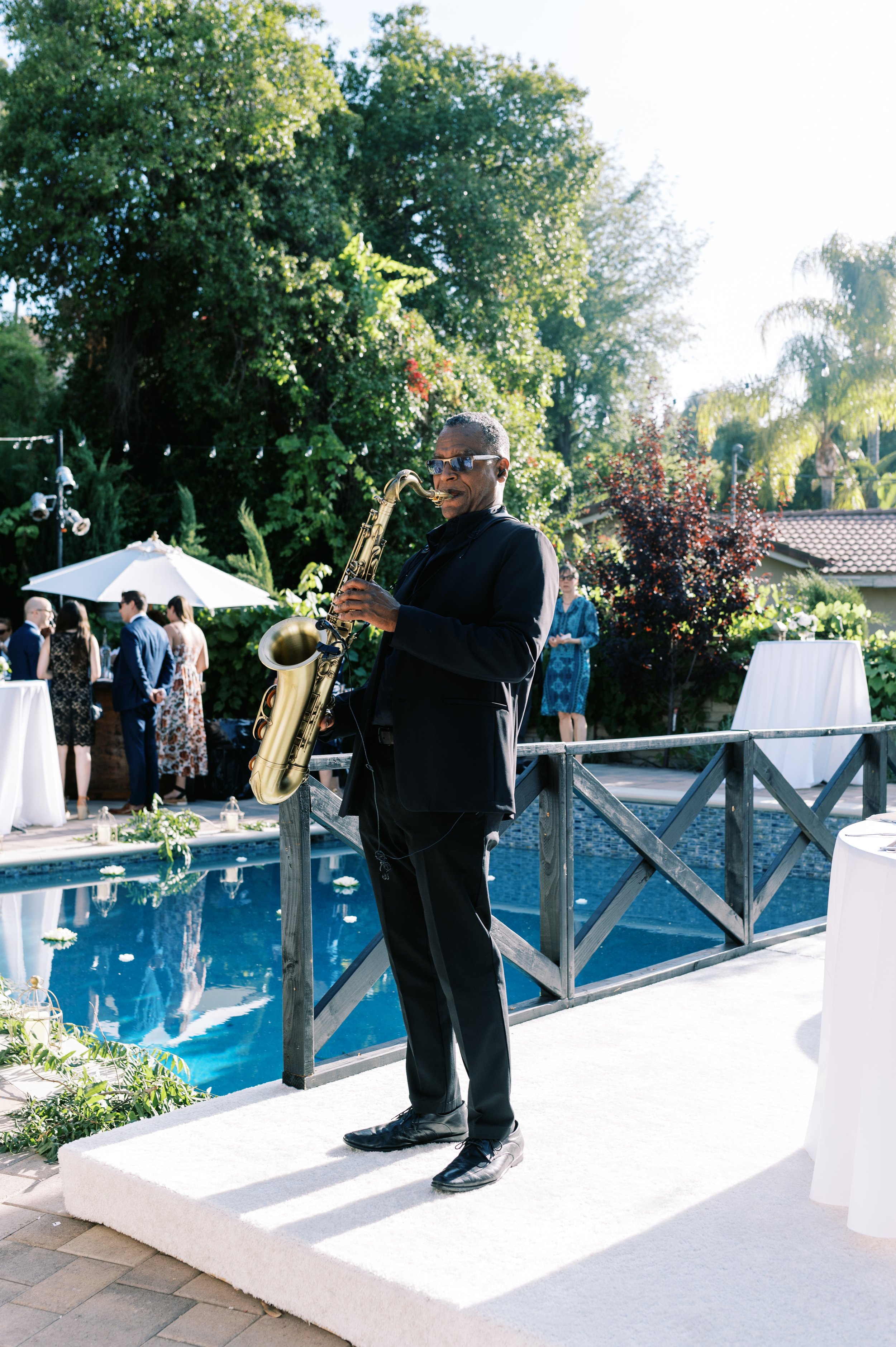 Backyard wedding cocktail hour with a live saxaphone player in Los Angeles.