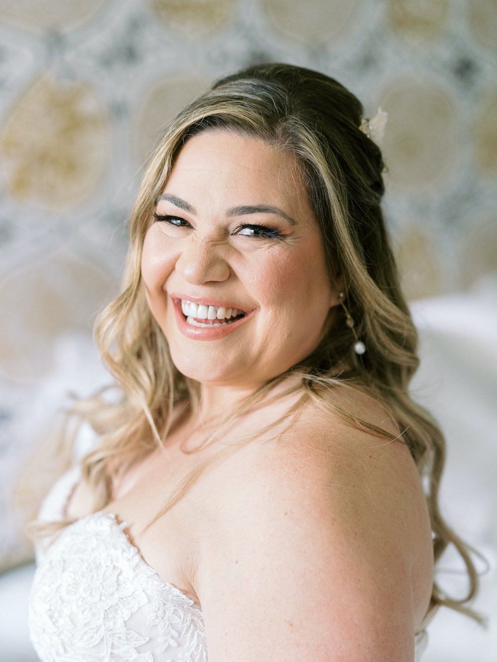 Glowing Los Angeles bride smiling after finalizing her wedding beauty routine.
