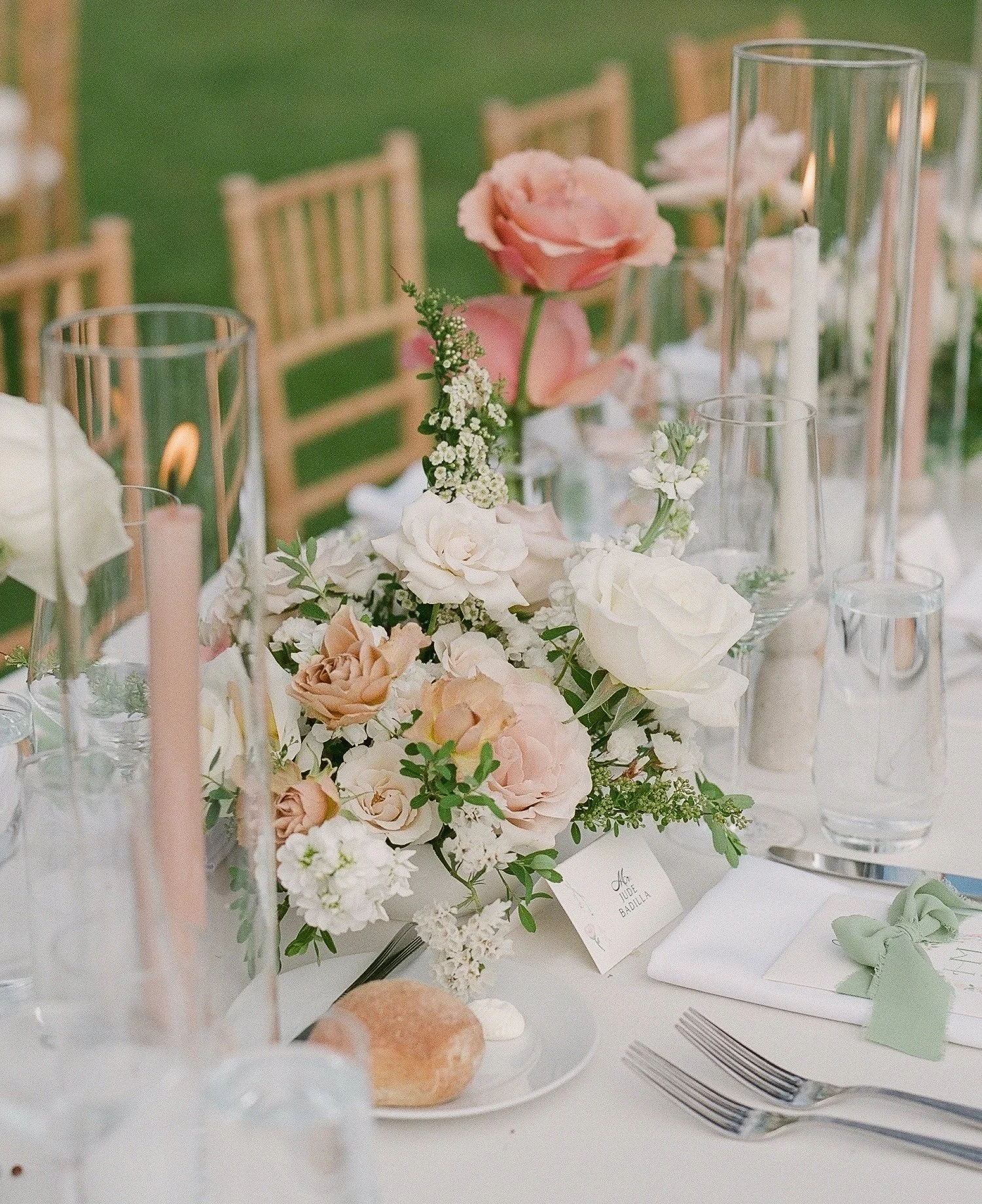 Elegant table centerpiece with pink and white flowers, candles, and glassware at what appears to be a wedding or special event. | Luxury Wedding Planner, Southern California