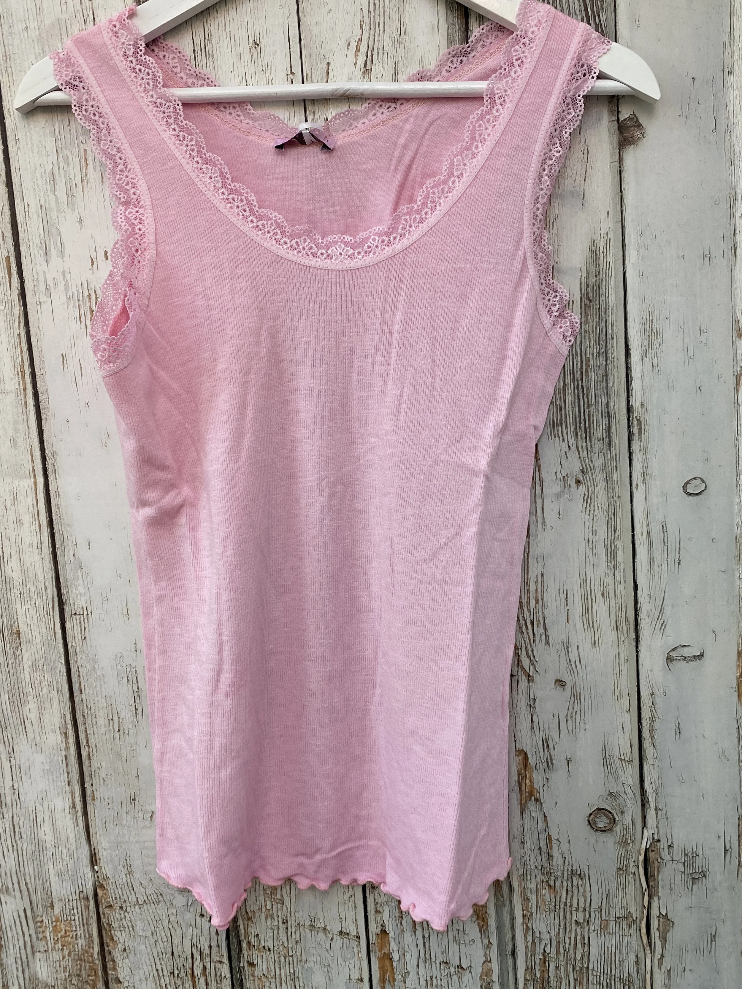 Pale pink vest top on a hanger