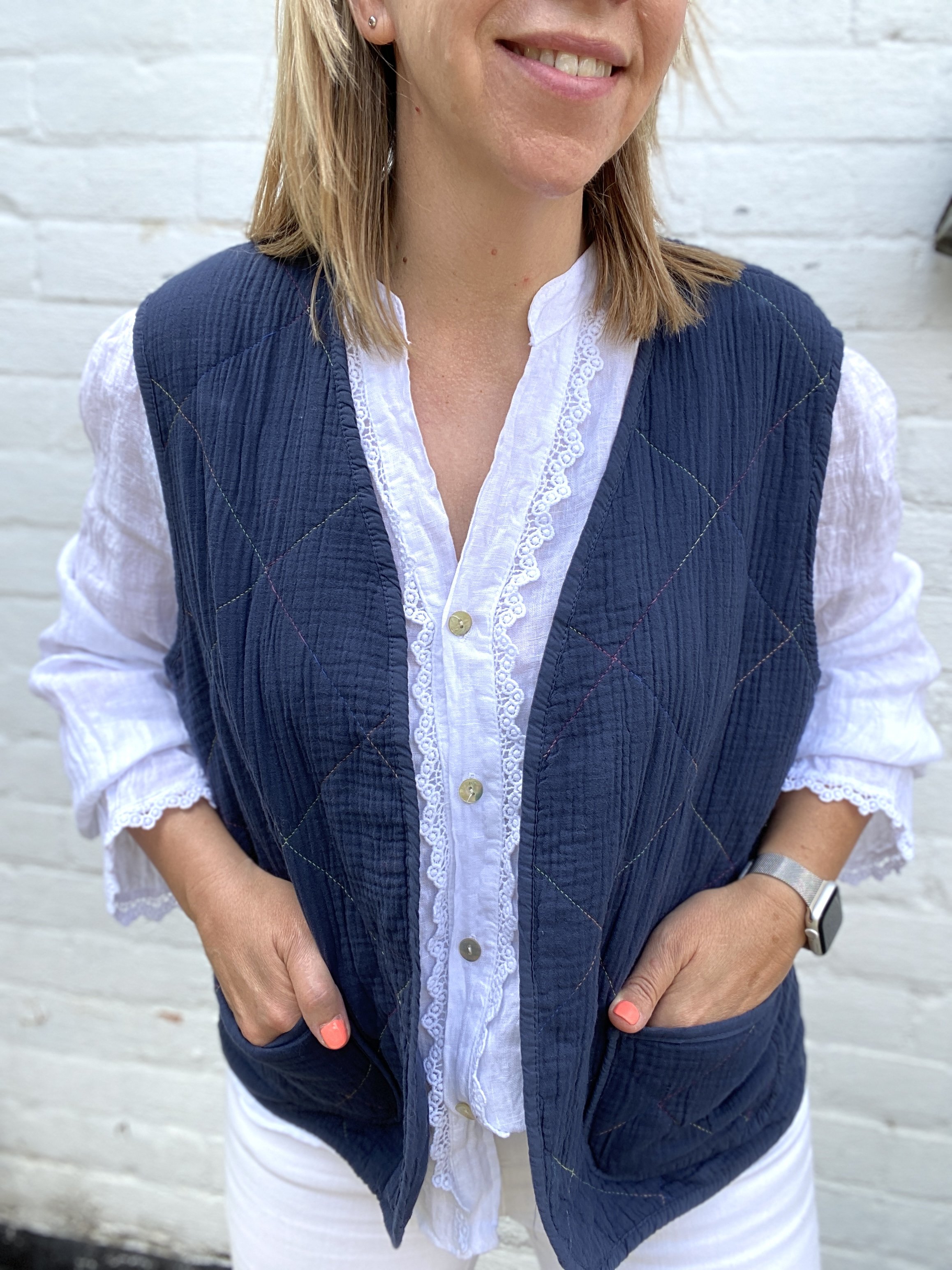 white linen shirt being worn with cotton gilet in navy