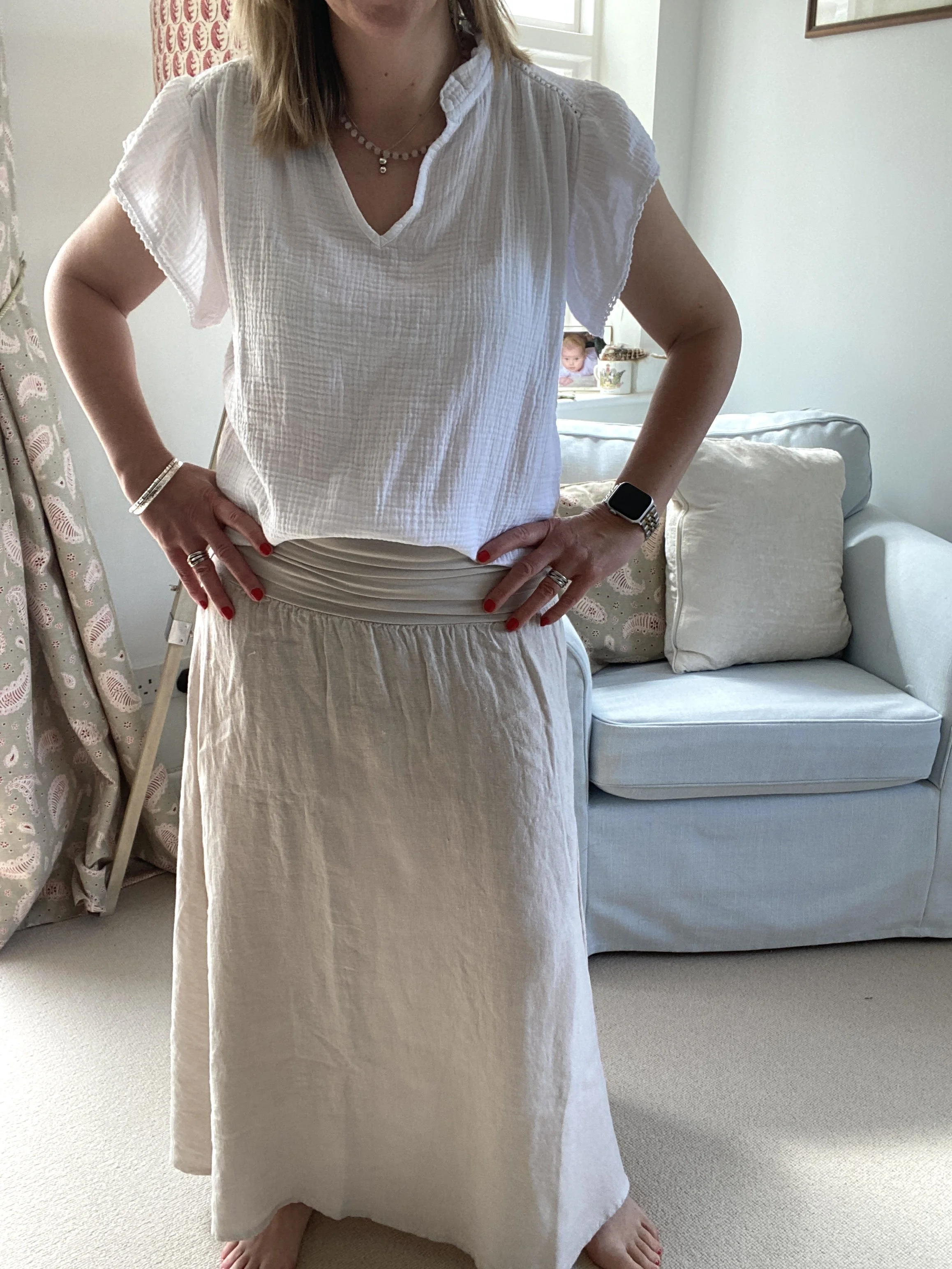 person wearing the stone coloured midi linen skirt and a white cotton short sleeve top