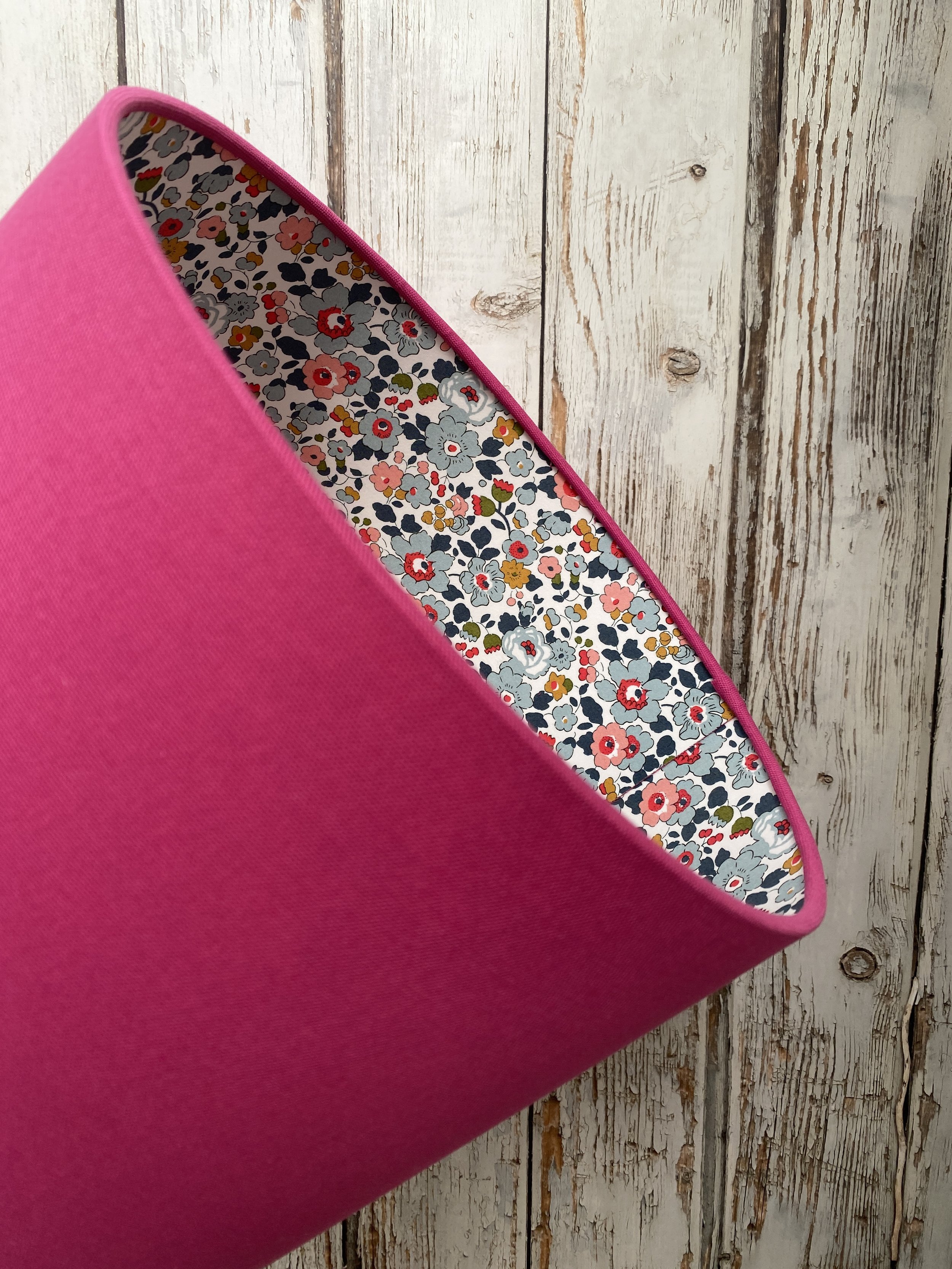 handmade lampshade covered in hot pink fabric with a Liberty floral print fabric lining