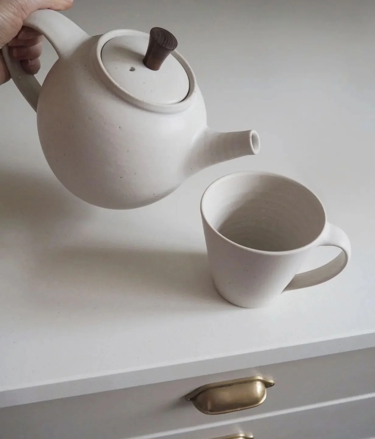 A teapot with a hand turned wooden knob and mug from my last firing. This teapot has a home to go to already but I am making more!

#handmadeteapot #wheelthrownpottery #contemporaryceramics #whiteinteriors #britishpottery