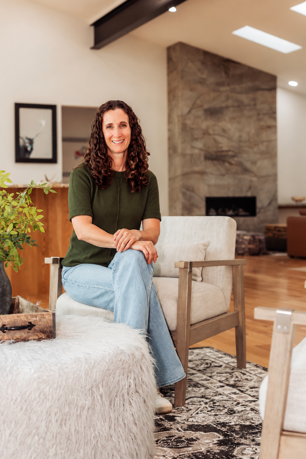 Carrie George, Grand County Colorado Realtor since 2004, seated in a mountain home