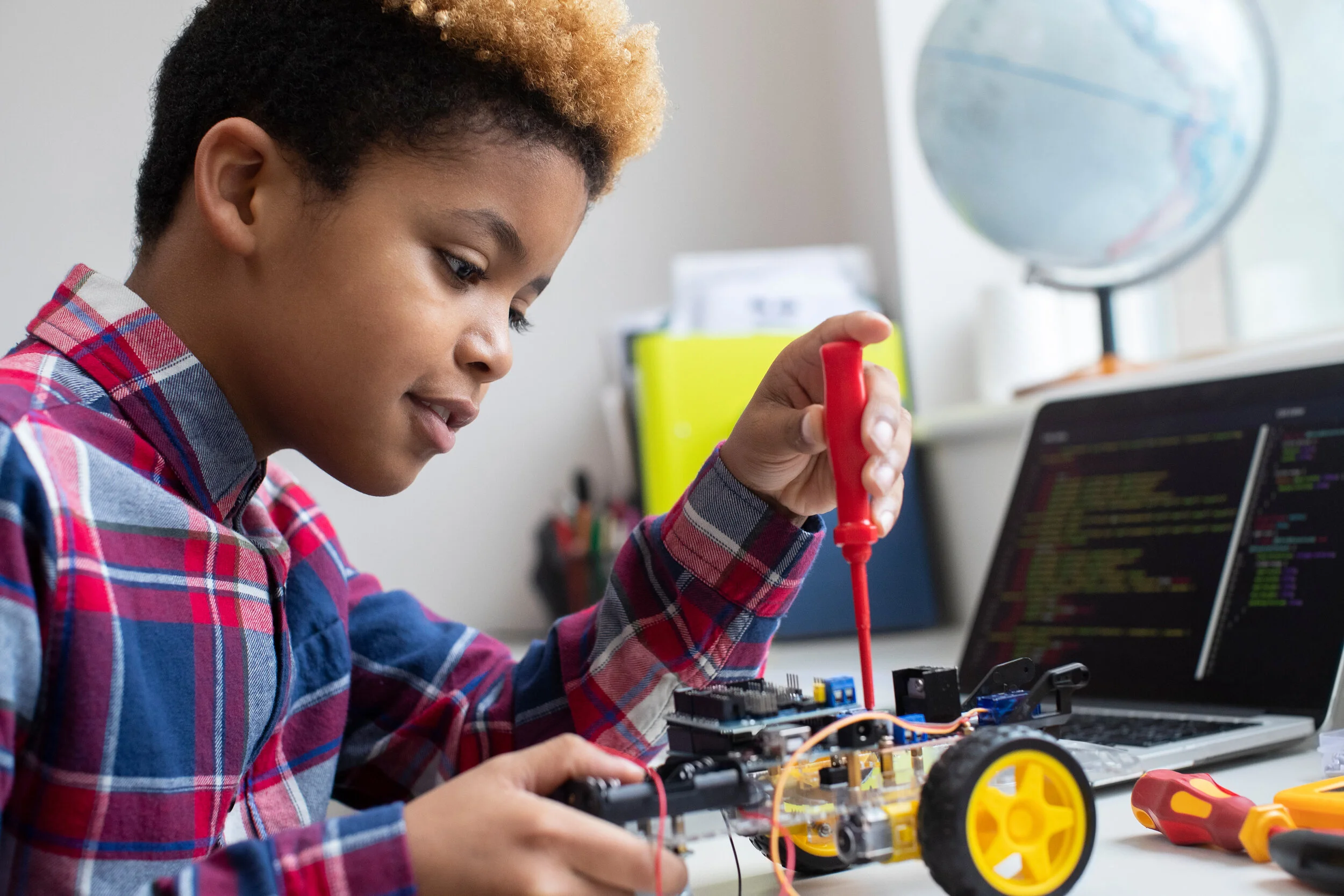 A young boy building a robot