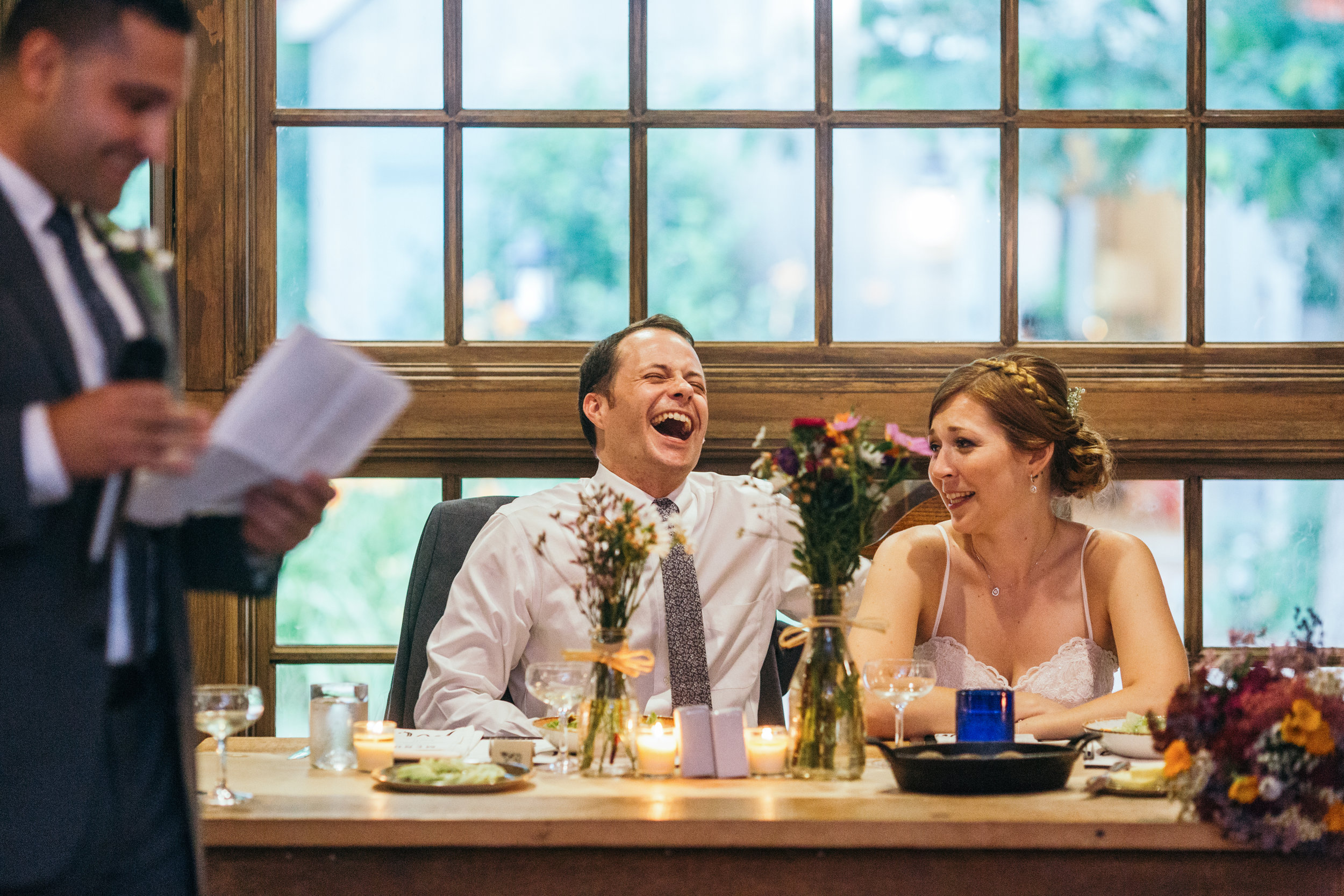 Bride and groom during their dinner reception at their rustic Waterloo Village wedding listening to toasts