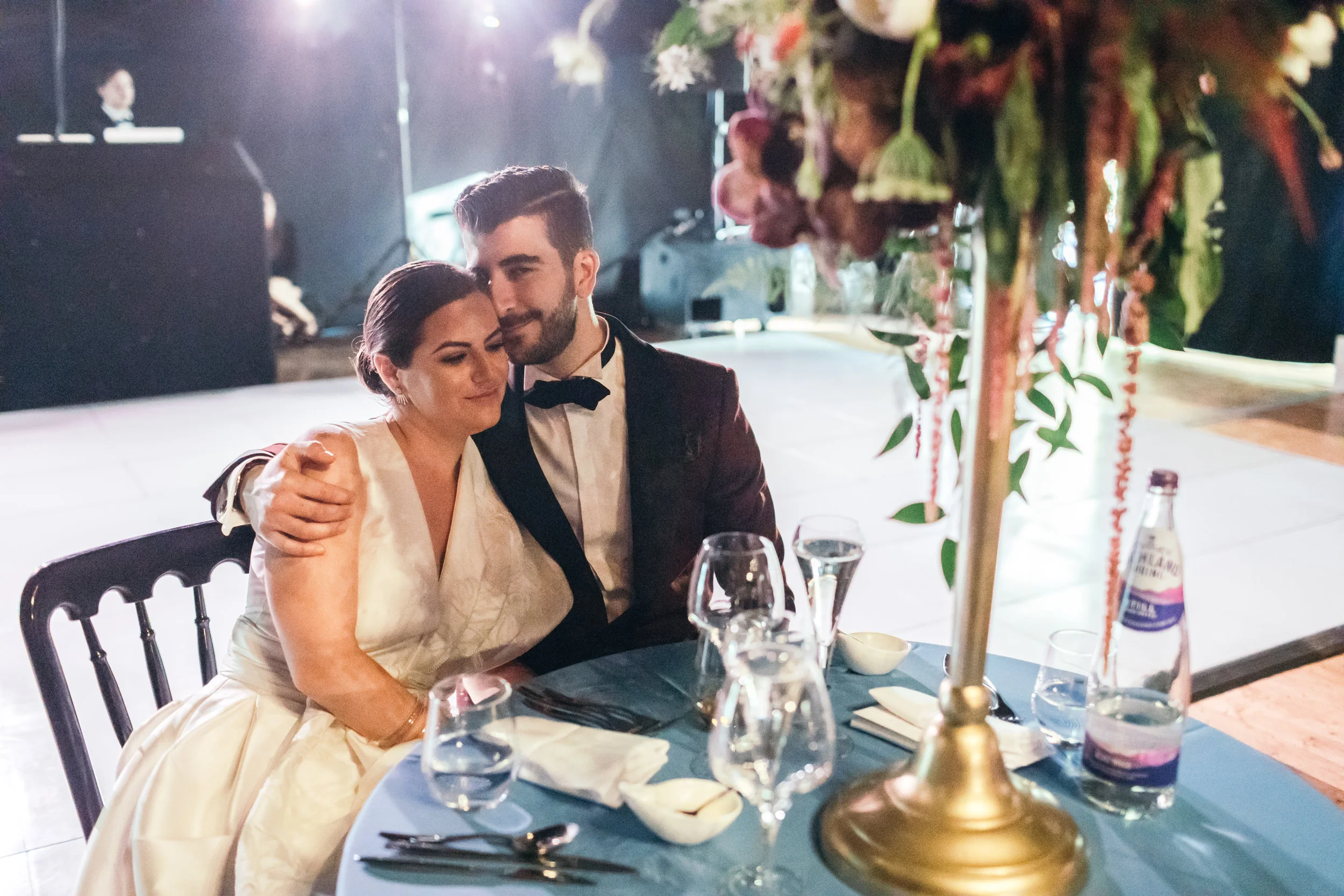 Bride and groom sitting at their table during night reception in Scotland castle outdoor wedding