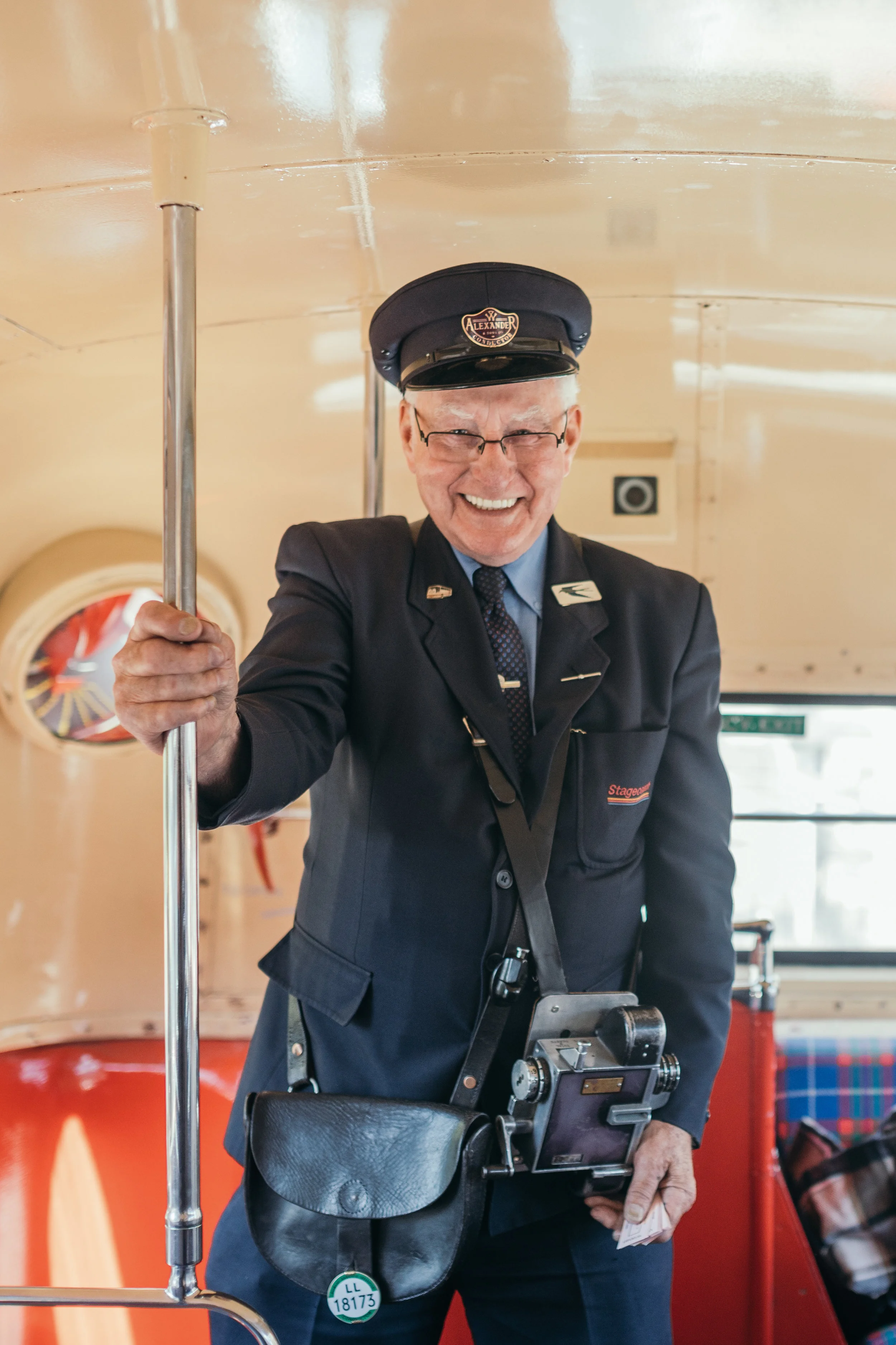 Portrait conductor in red double decker bus in Scotland Castle Outdoor Destination Wedding