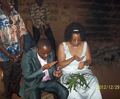 Yvette and her husband Constantin during their traditional wedding in his Cameroonian village, eating dimdim (a small seed).