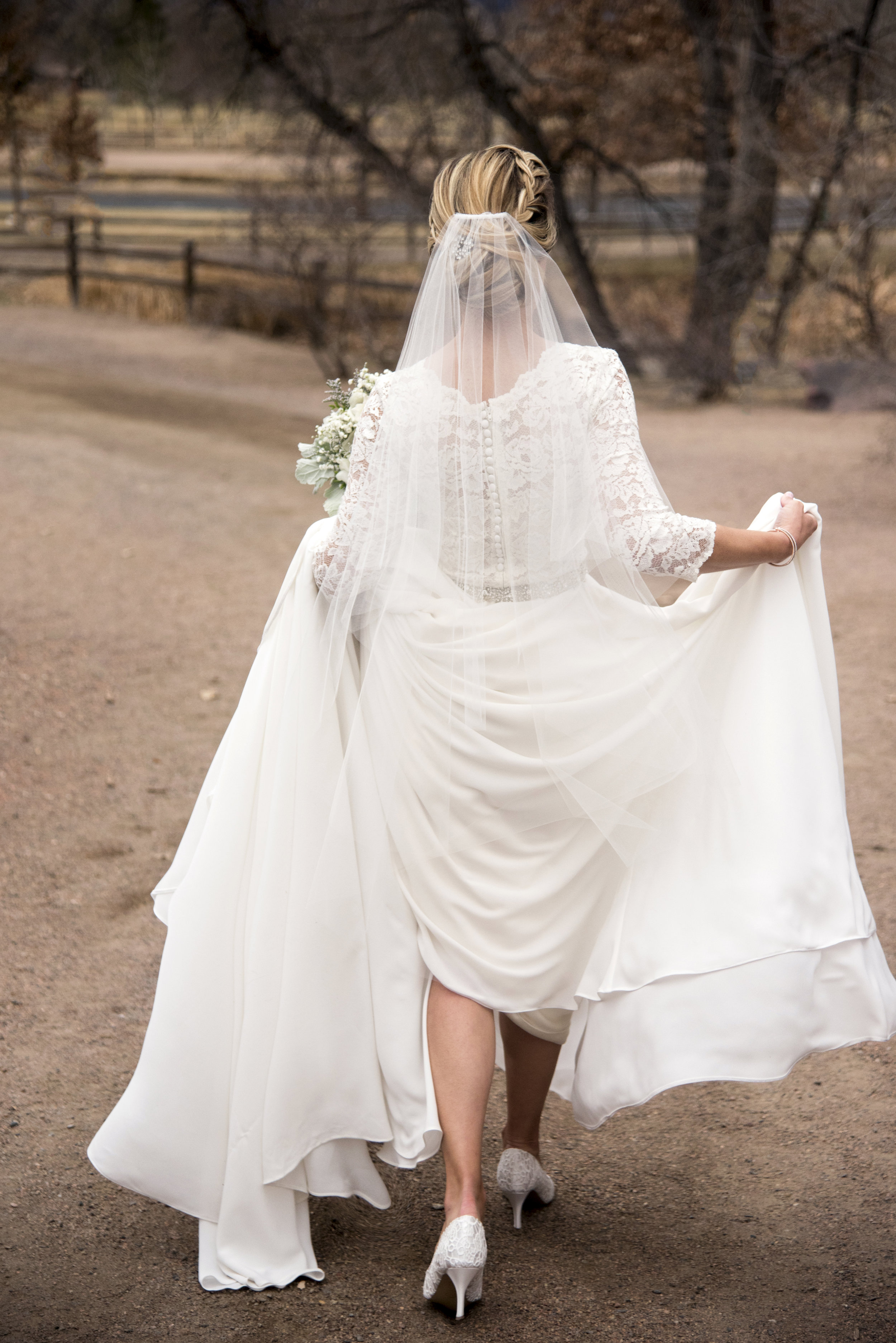 Bride walking, lifting her dress's train | Brad and Mike's Outdoor Wedding at Hudson Gardens | Colorado Springs, Colorado | Farm Wedding Photographer | Apollo Fields Wedding Photographer