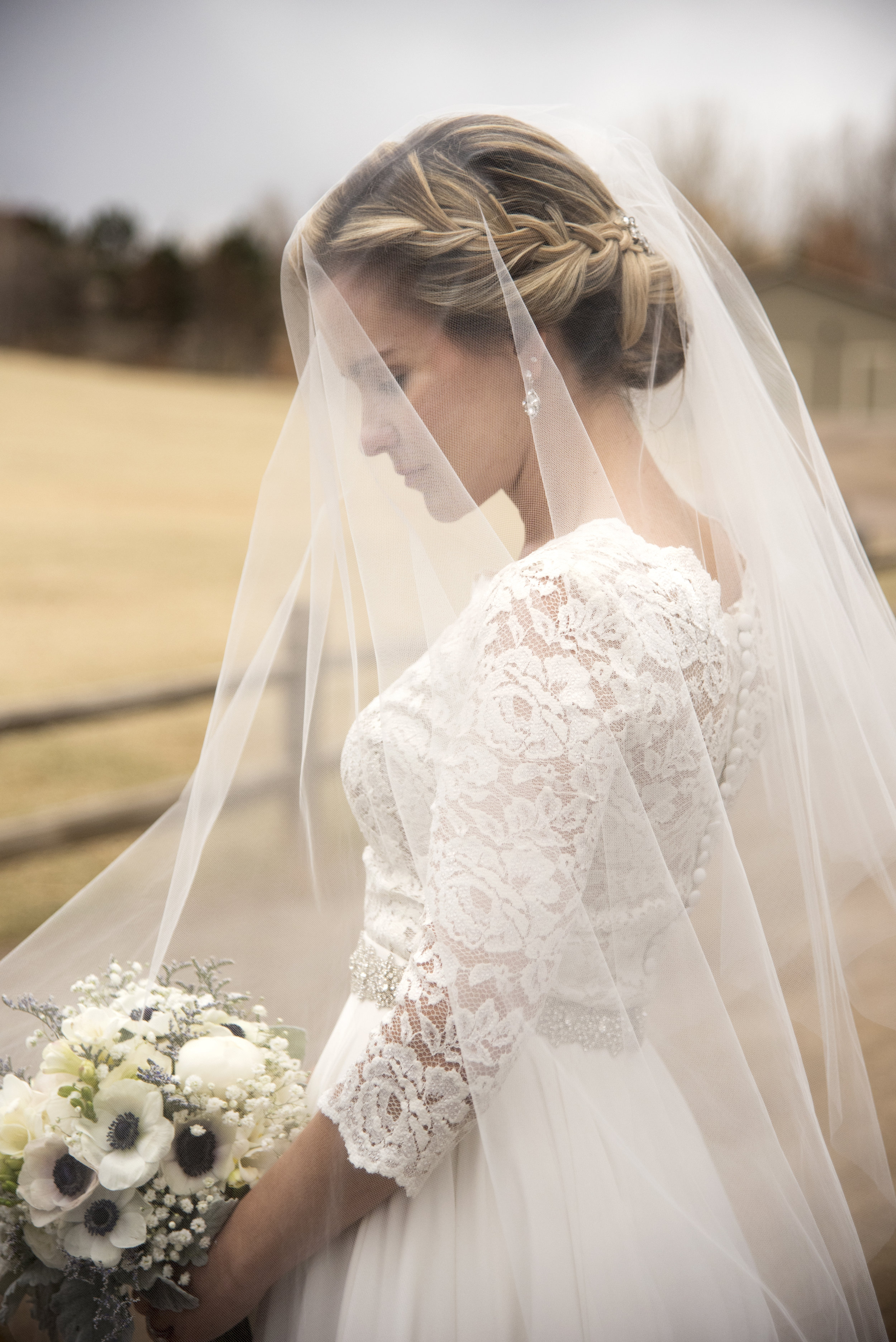 Bride looking down at bouquet | Mary and Brad's outdoor wedding photography at Hudson Gardens | Colorado Springs, Colorado | Farm Wedding Photographer | Apollo Fields Photojournalism