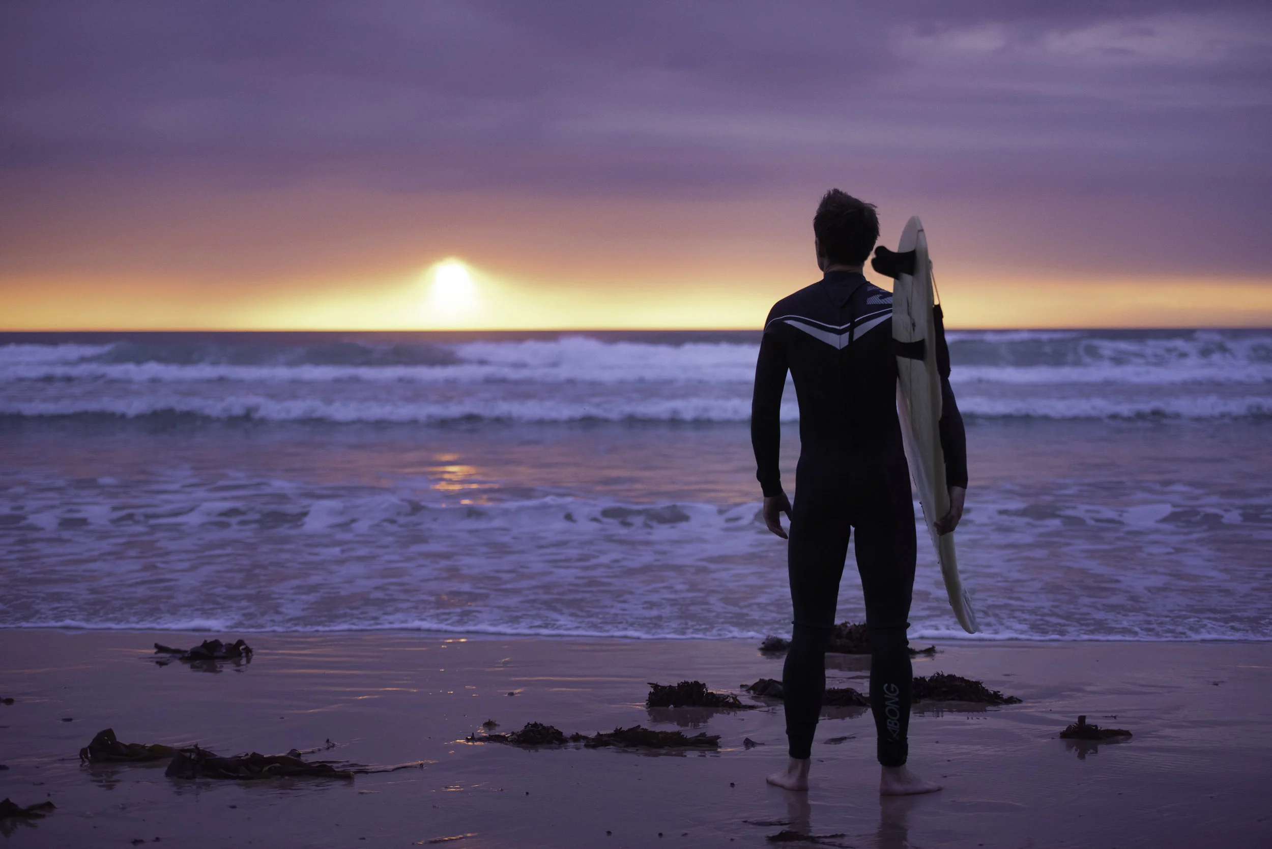 Jersey photographer: surfer at sunset at St Ouens
