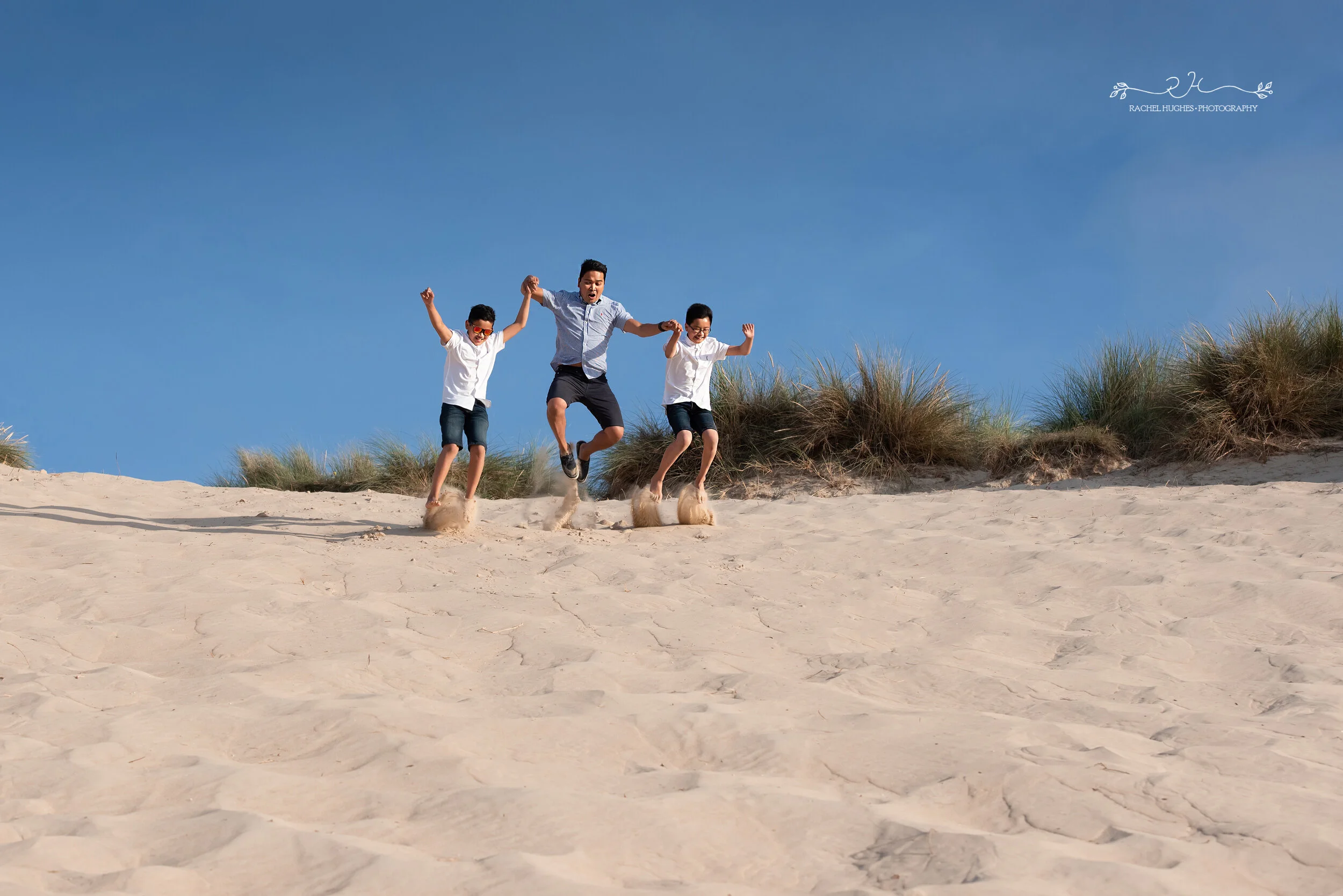 Jersey photographer - family jumping down sand dunes