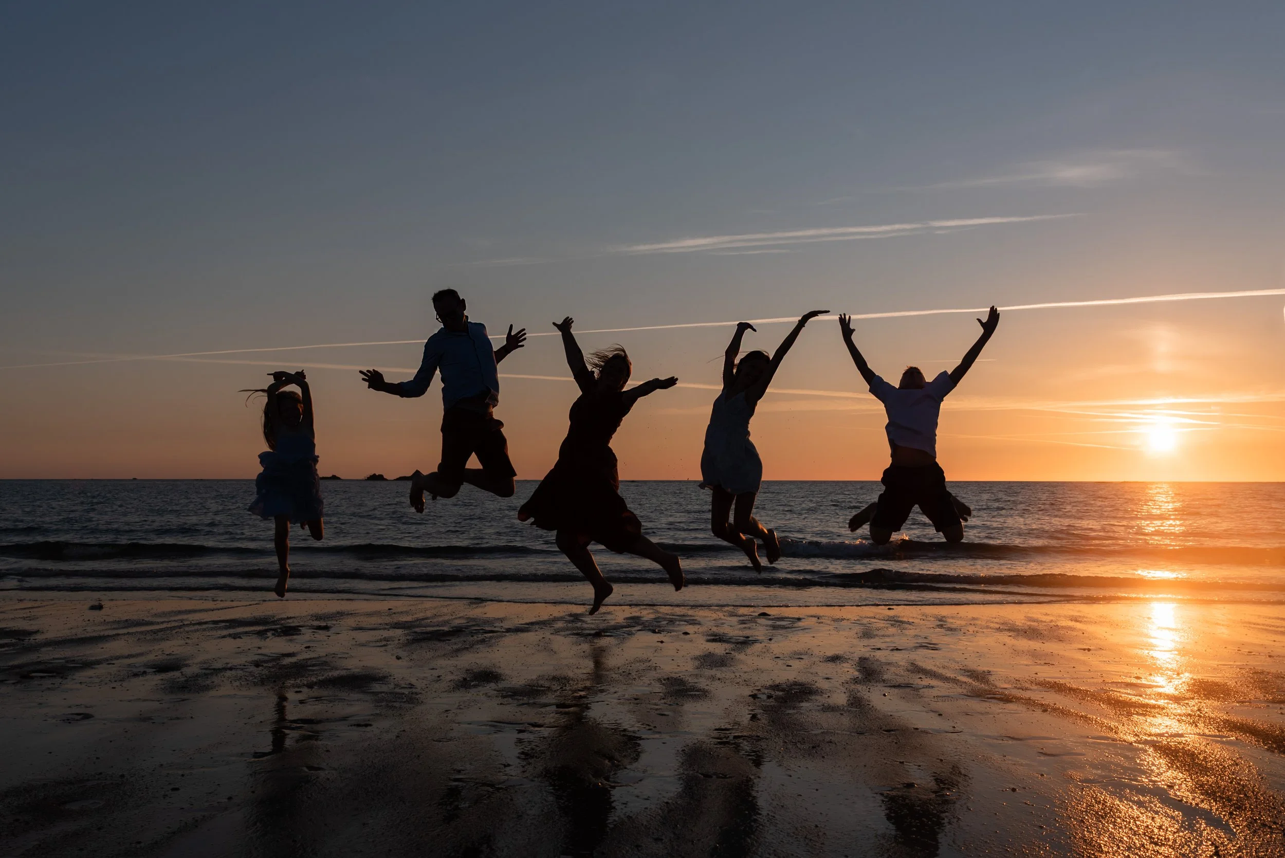 Jersey photographer - family jumping silhouette at beach