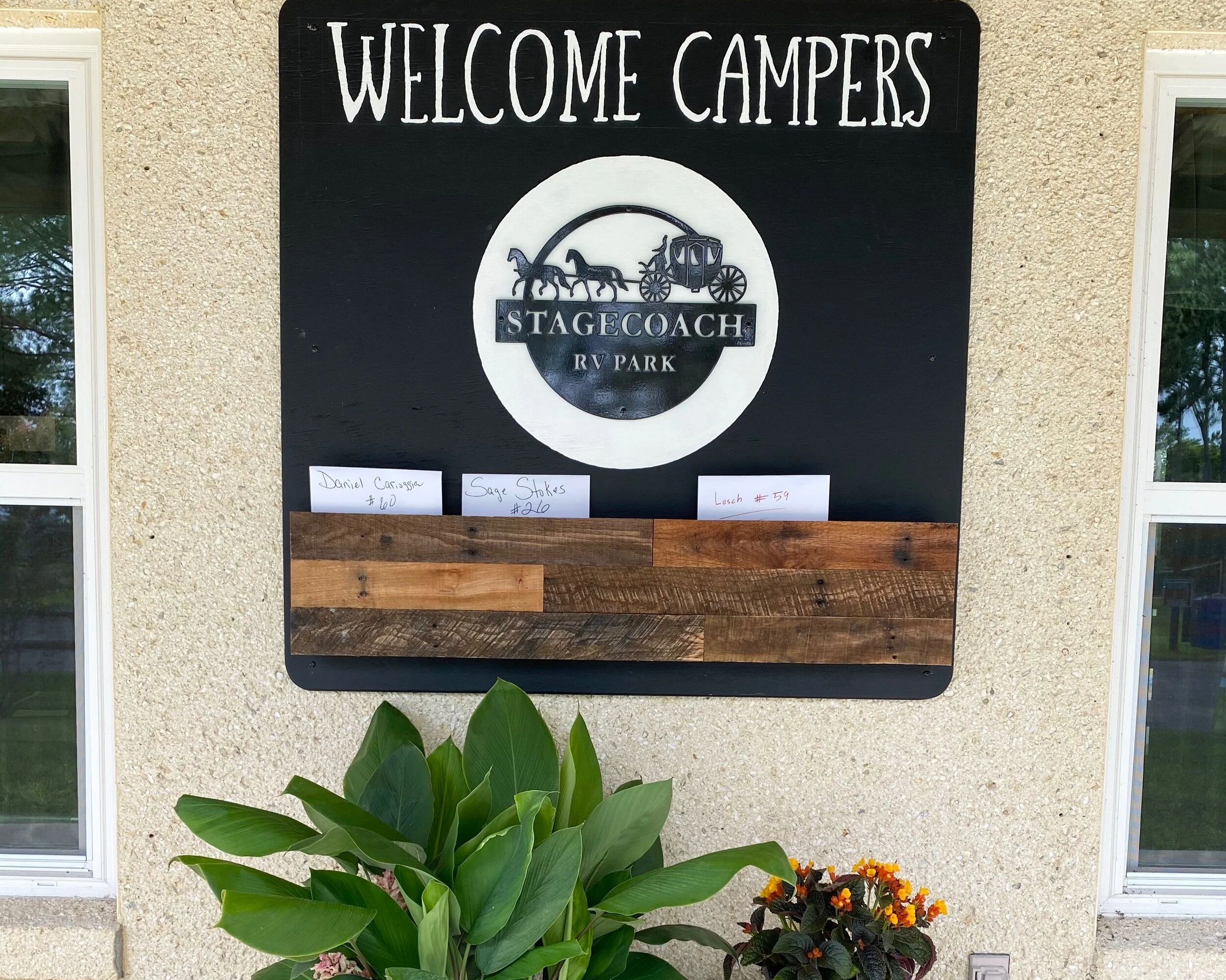 A black welcome sign at Stagecoach RV Park with a logo.
