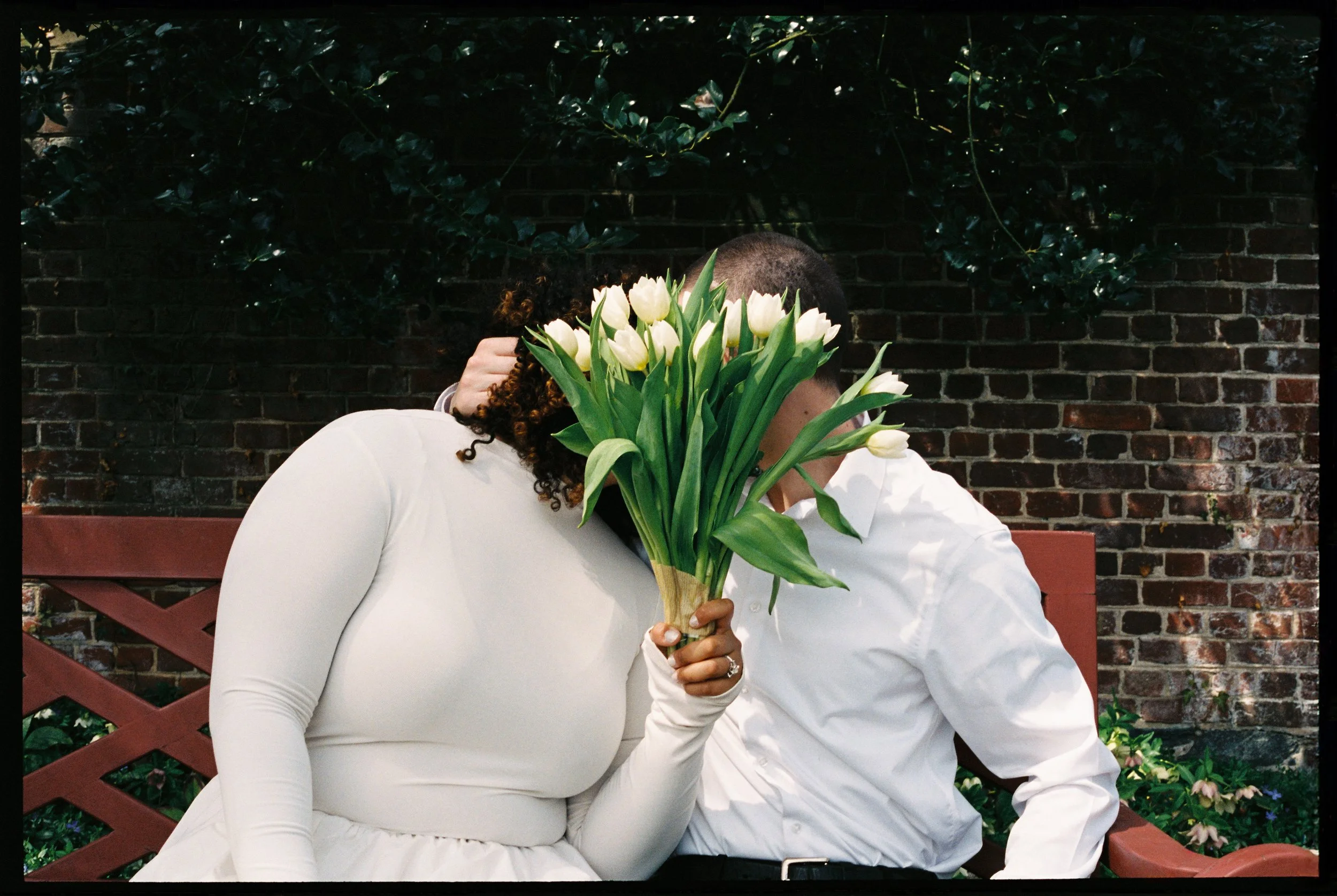Romantic couple portrait with tulips during spring engagement session at William Paca House Annapolis Maryland photographed on 35mm film