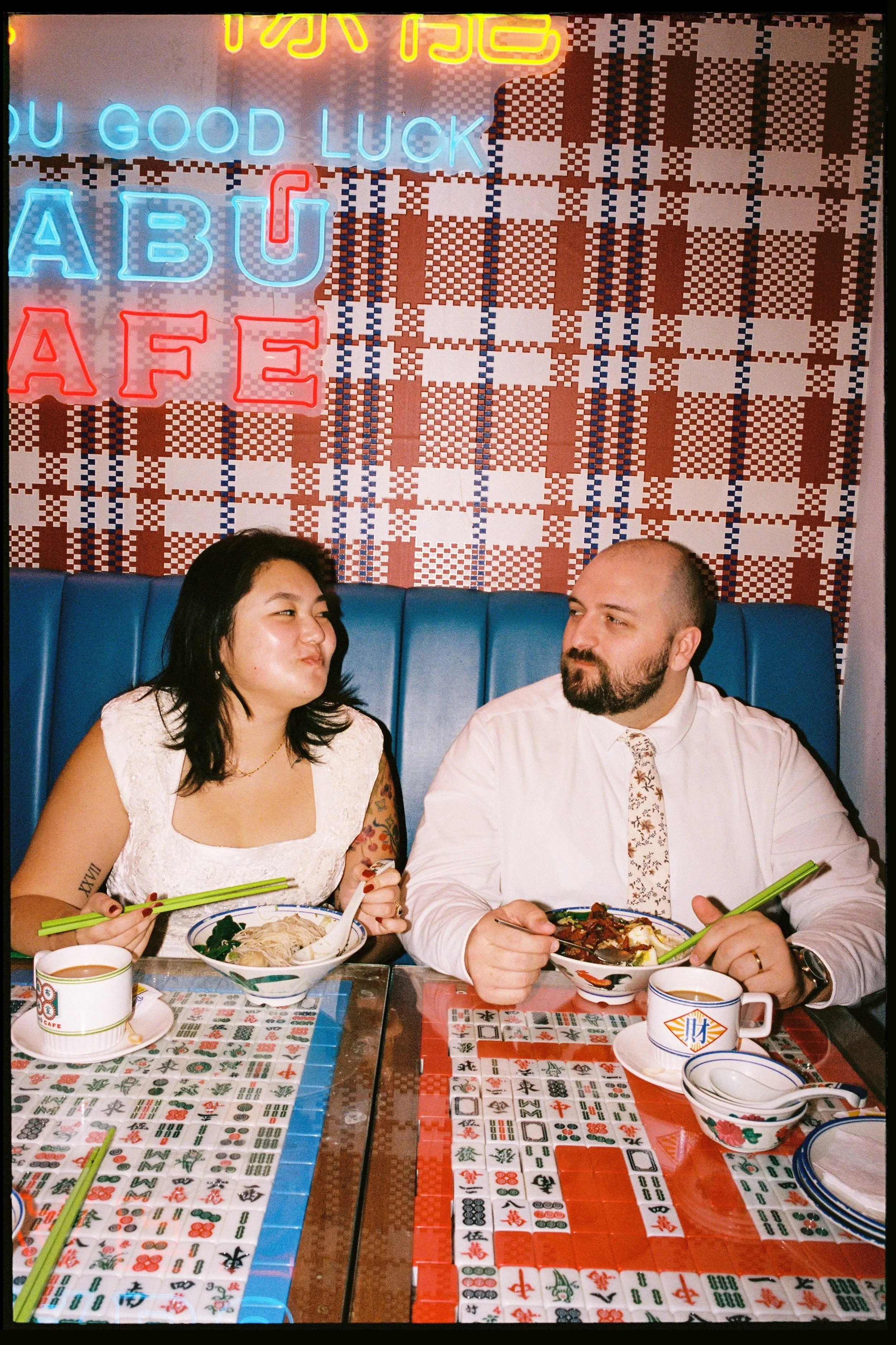 Newlyweds sharing a meal at Chinatown cafe after New York City Hall elopement on 35mm film