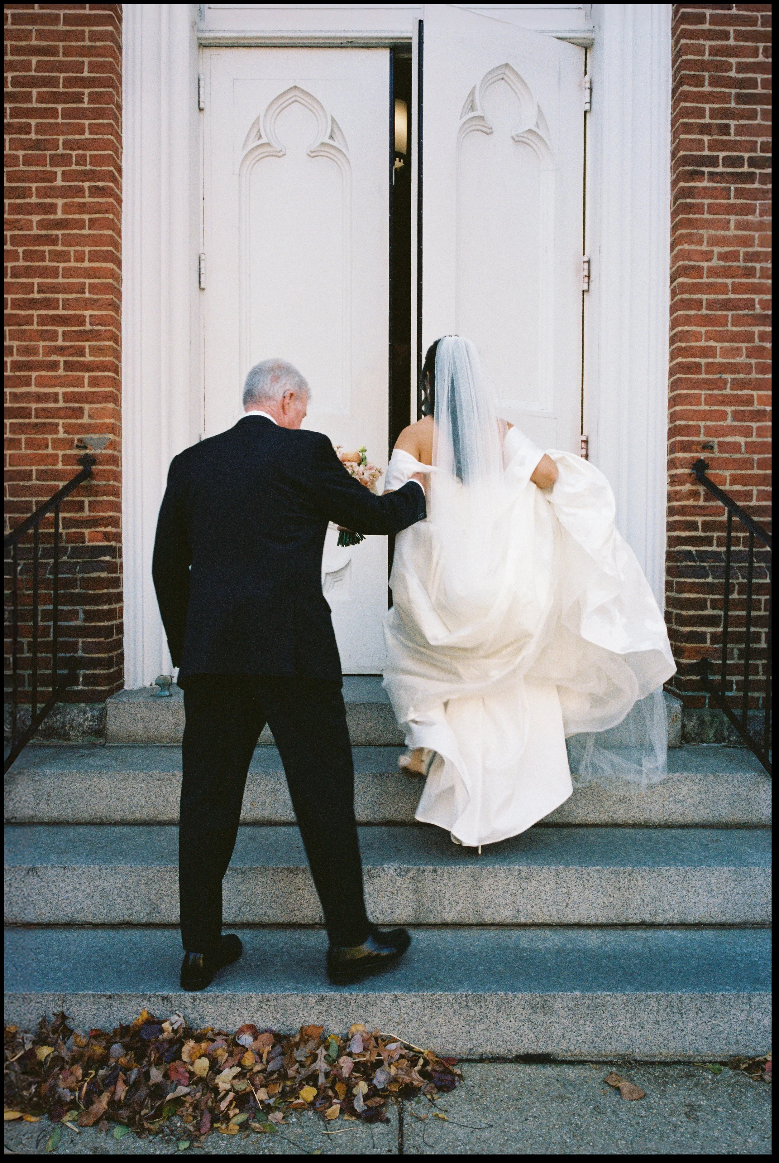 Father helping bride up church steps at St Marys Church wedding in Annapolis Maryland