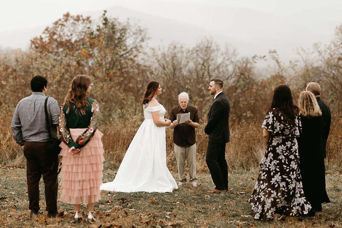  A couple reads their elopement vows under light rain at the Dicky Ridge Visitor Center in Shenandoah National Park 