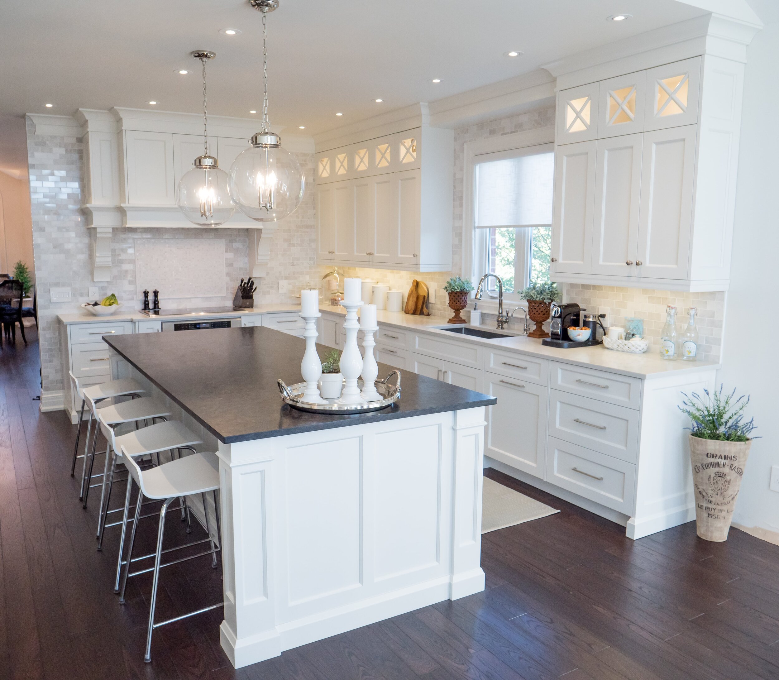 A bright kitchen with an island and four bar stools.