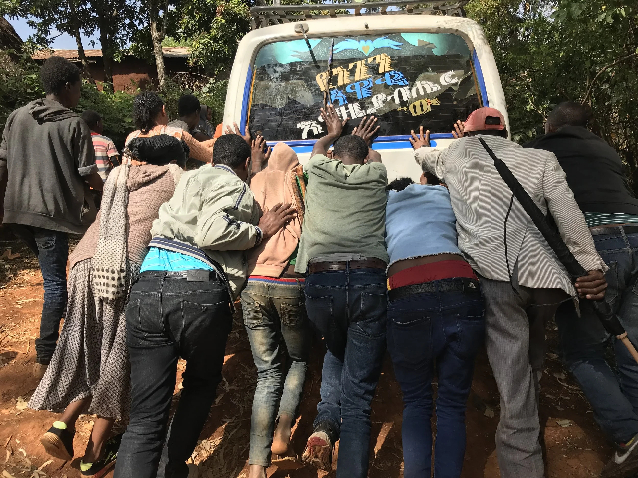 Random villagers along the dirt road to Gofora help push our van up the hill toward the town square.