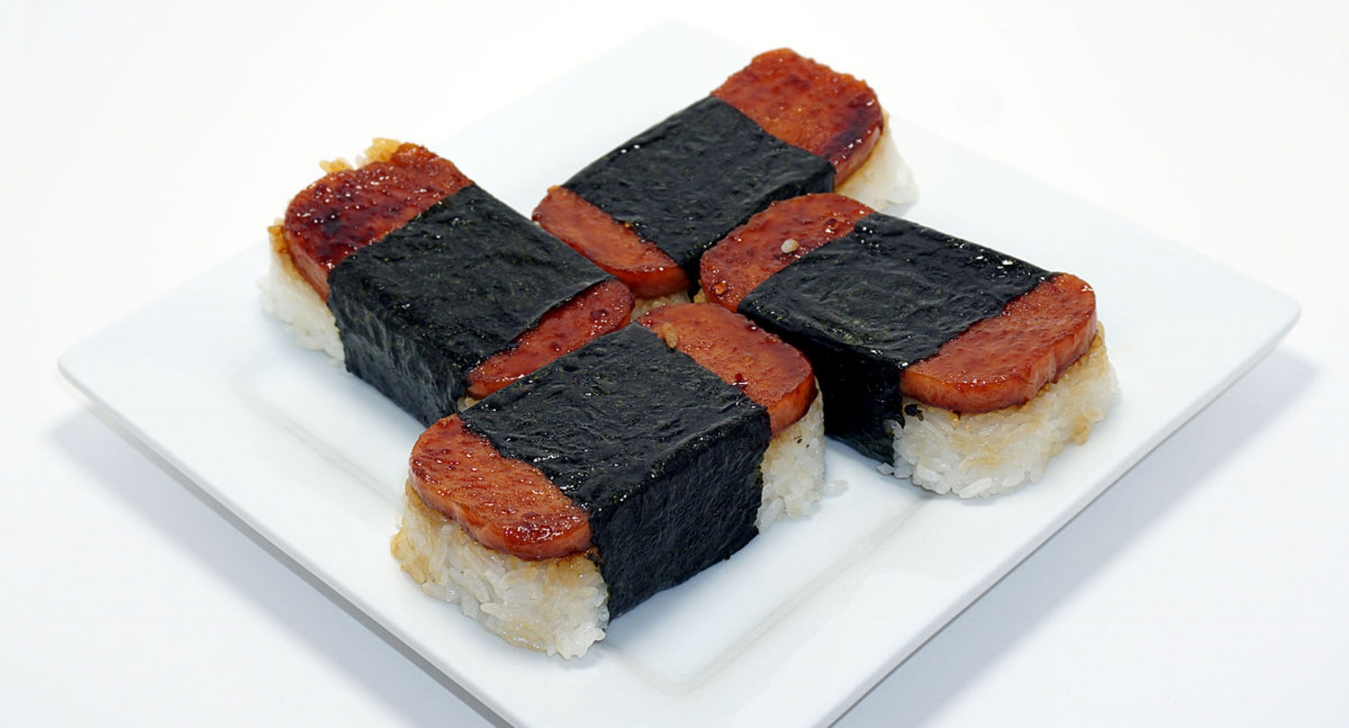 SPAM MUSUBI a popular snack and lunch food in Hawaii composed of a slice of grilled Spam on top of a block of rice, wrapped together with nori in the tradition of Japanese omusubi
