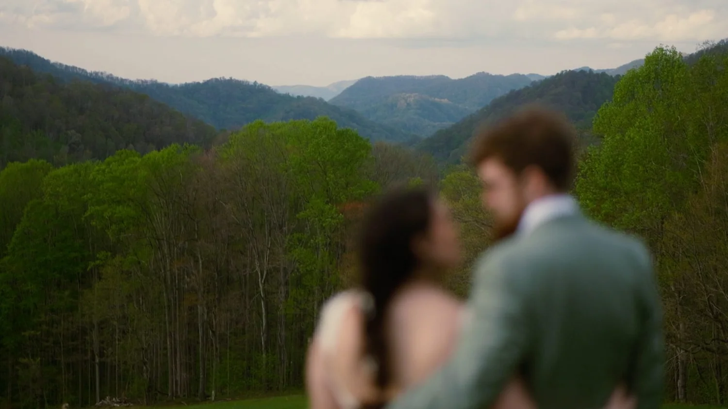 A couple embracing above a mountain valley