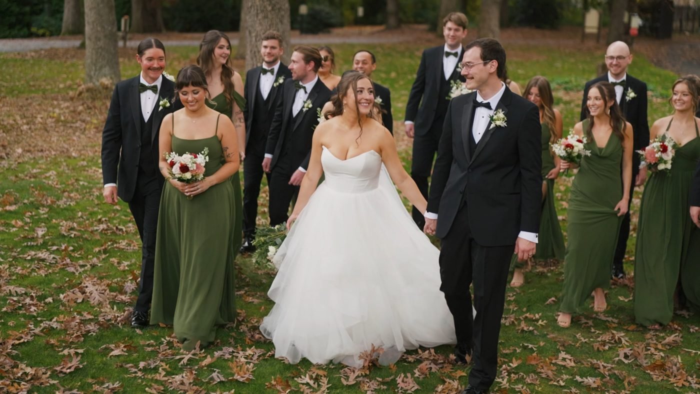 Bride and groom walking with their wedding party in green dresses