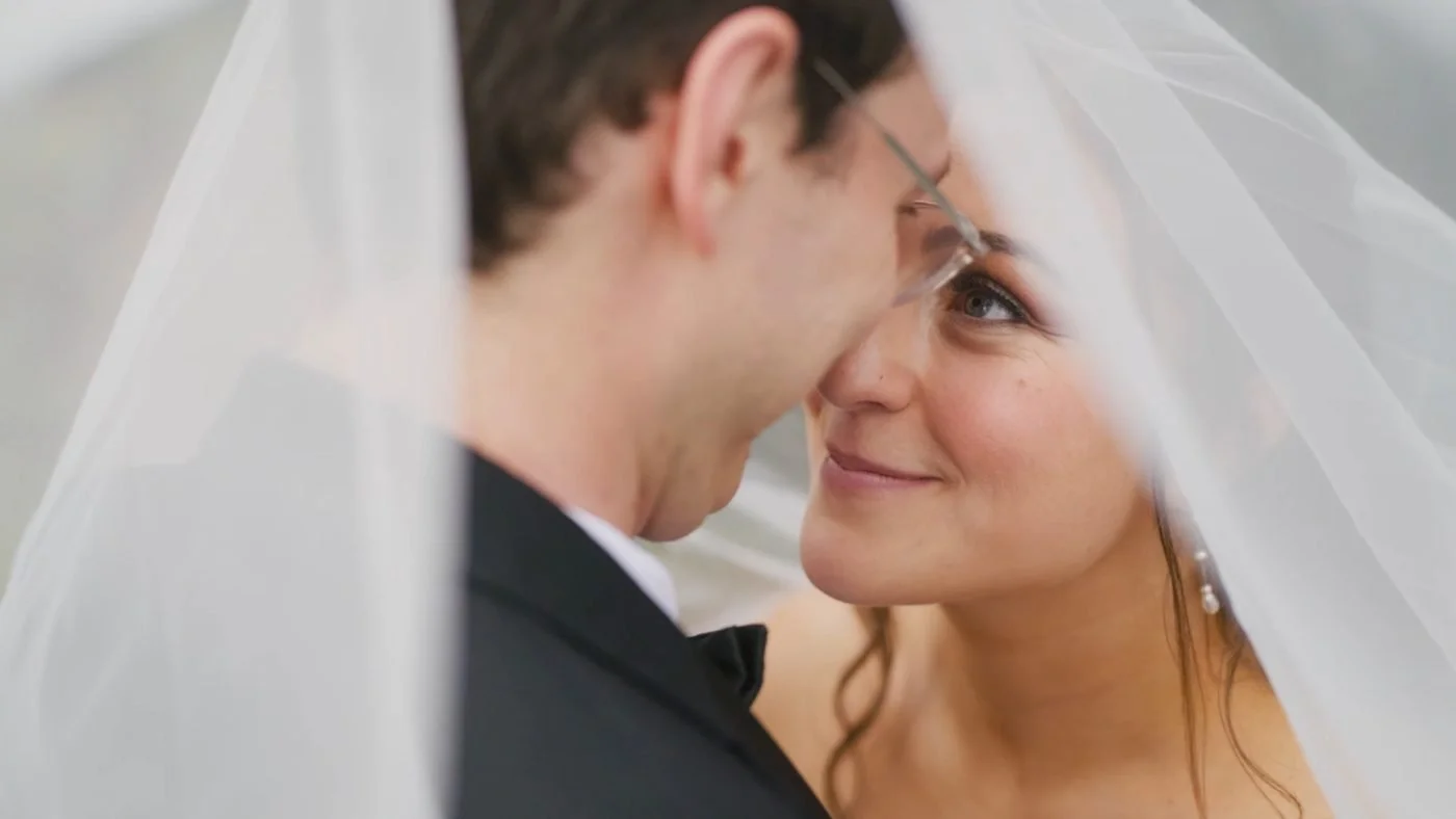 A bride smiling at her groom under her veil