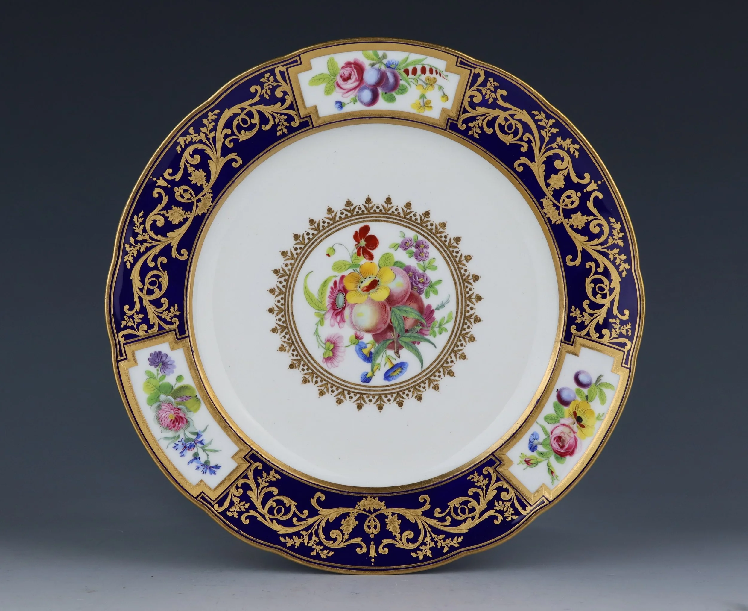 Sèvres plate decorated with rich gilt arabesques on a bleu nouveau ground and panels of flowers, 1787