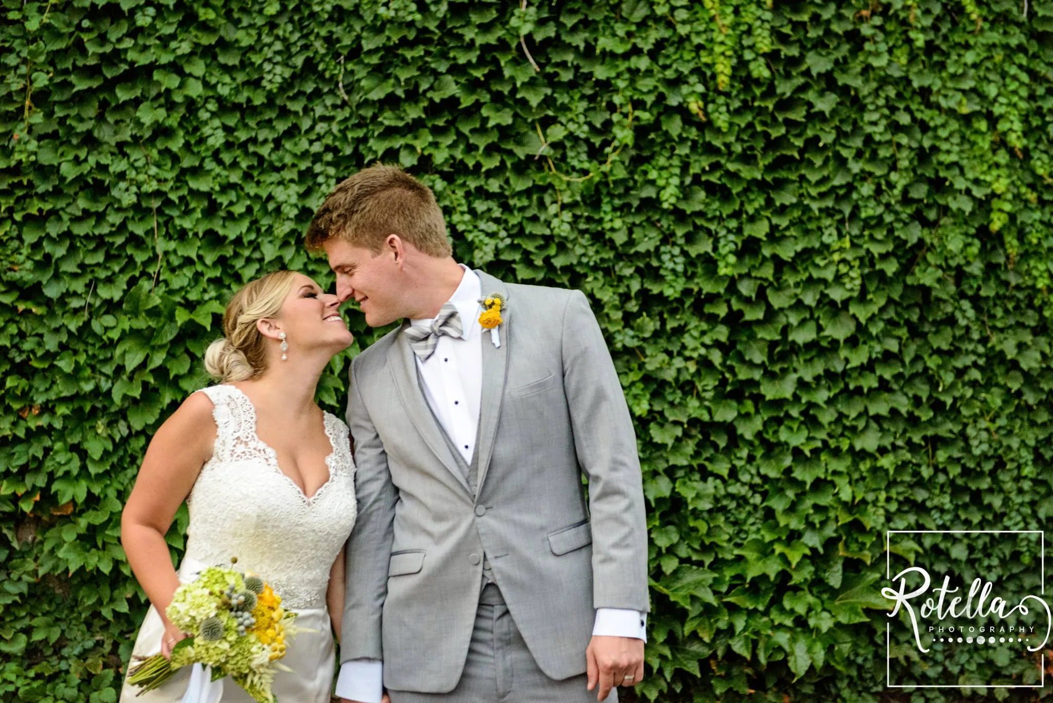 Bride and groom in front of ivy wall