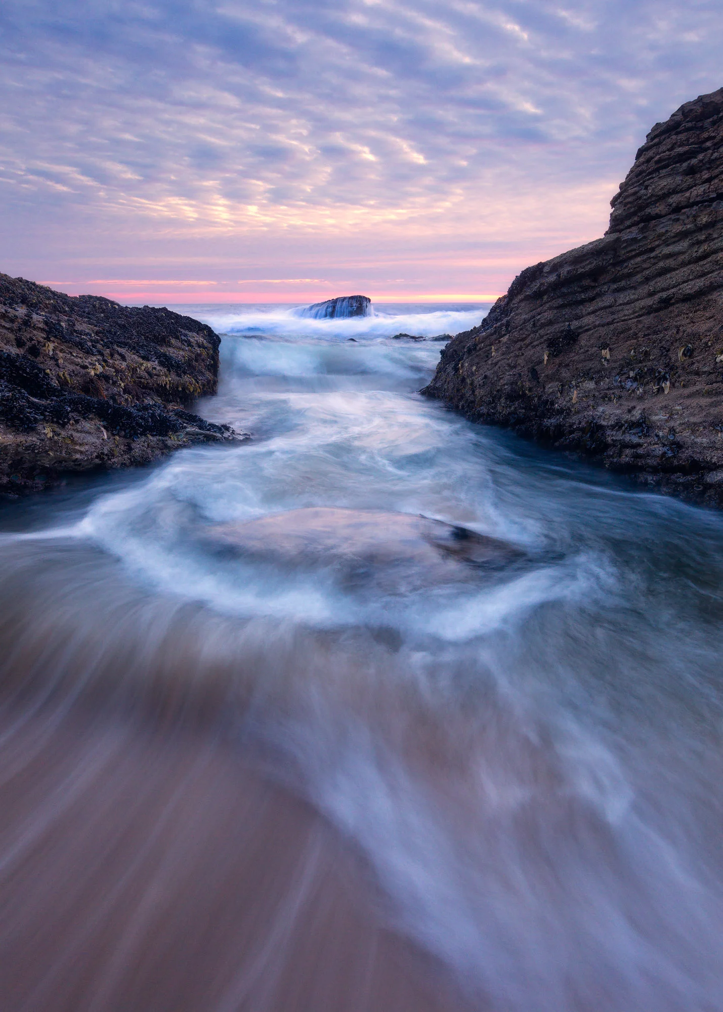 A wave rushes back through the rocks during a huge swell in Davenport