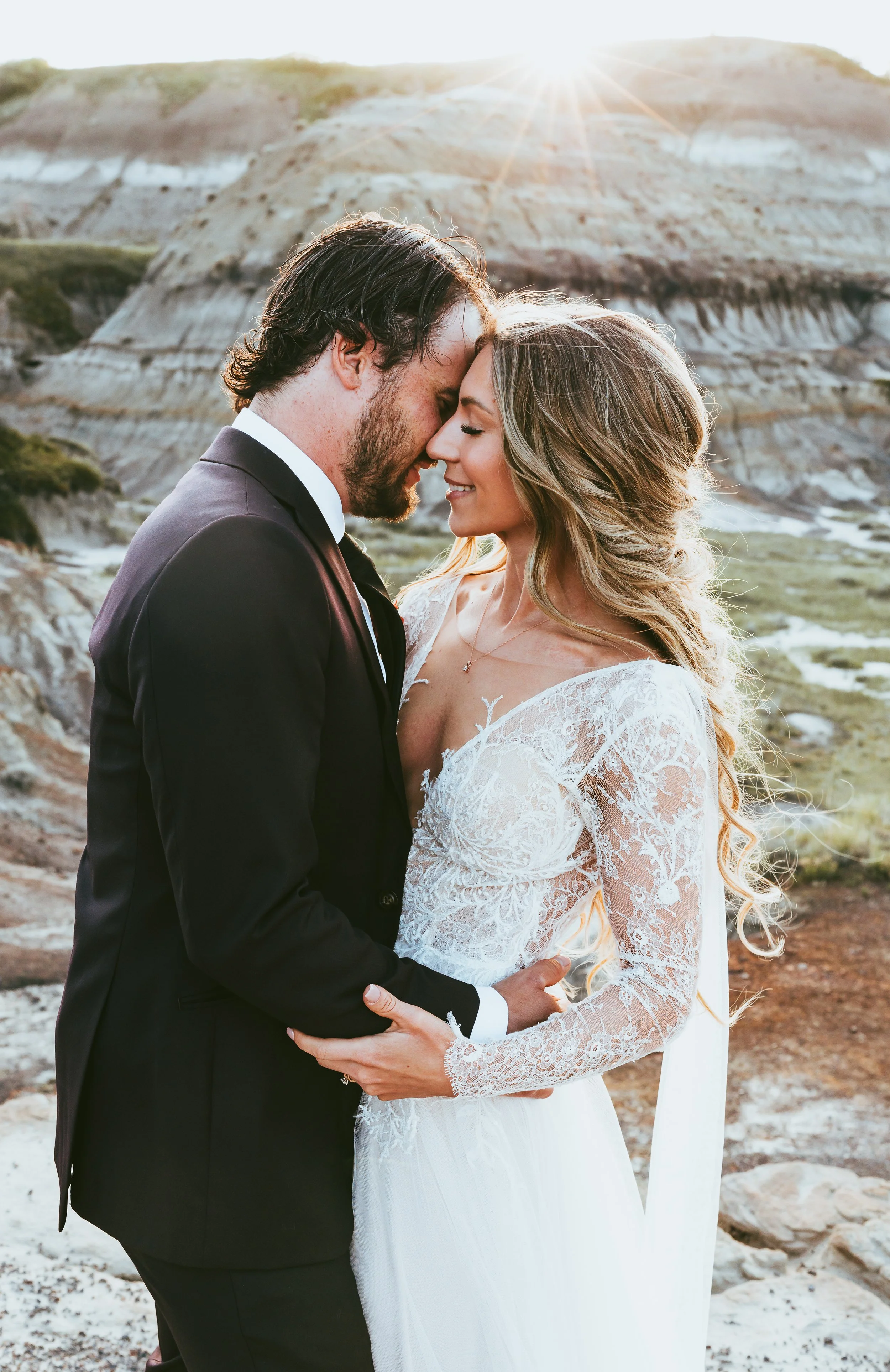 Intimate bride and groom during sunset elopement in Alberta's Badlands with soft sunset and natural landscape