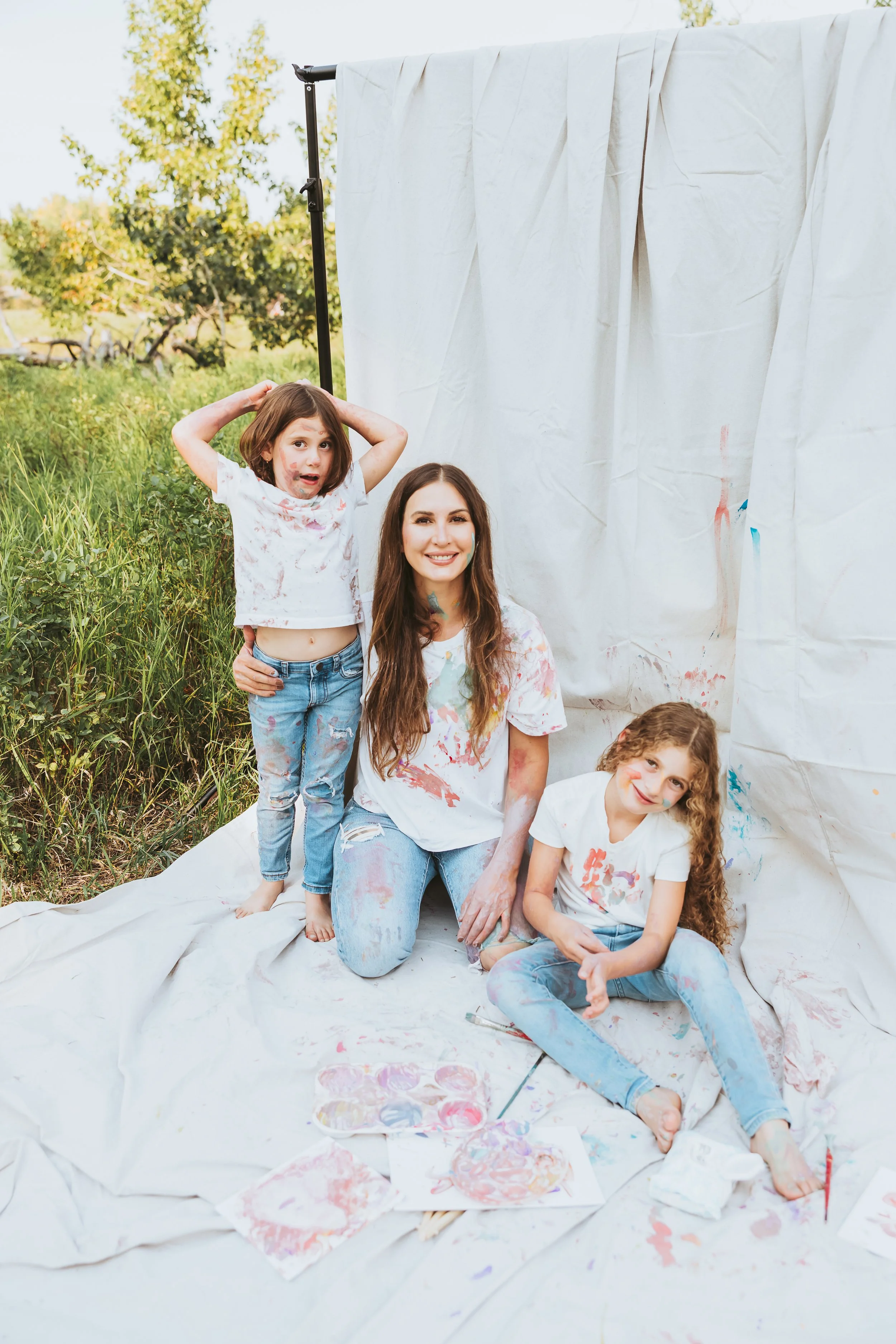 Mother and two daughters enjoying a family paint session outdoors during a creative paint mini session in Calgary Alberta.