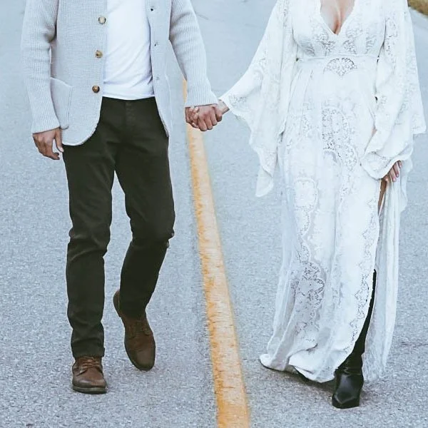 Pregnant woman wearing a vintage white lace dress during a dreamy mountain maternity session in Banff.