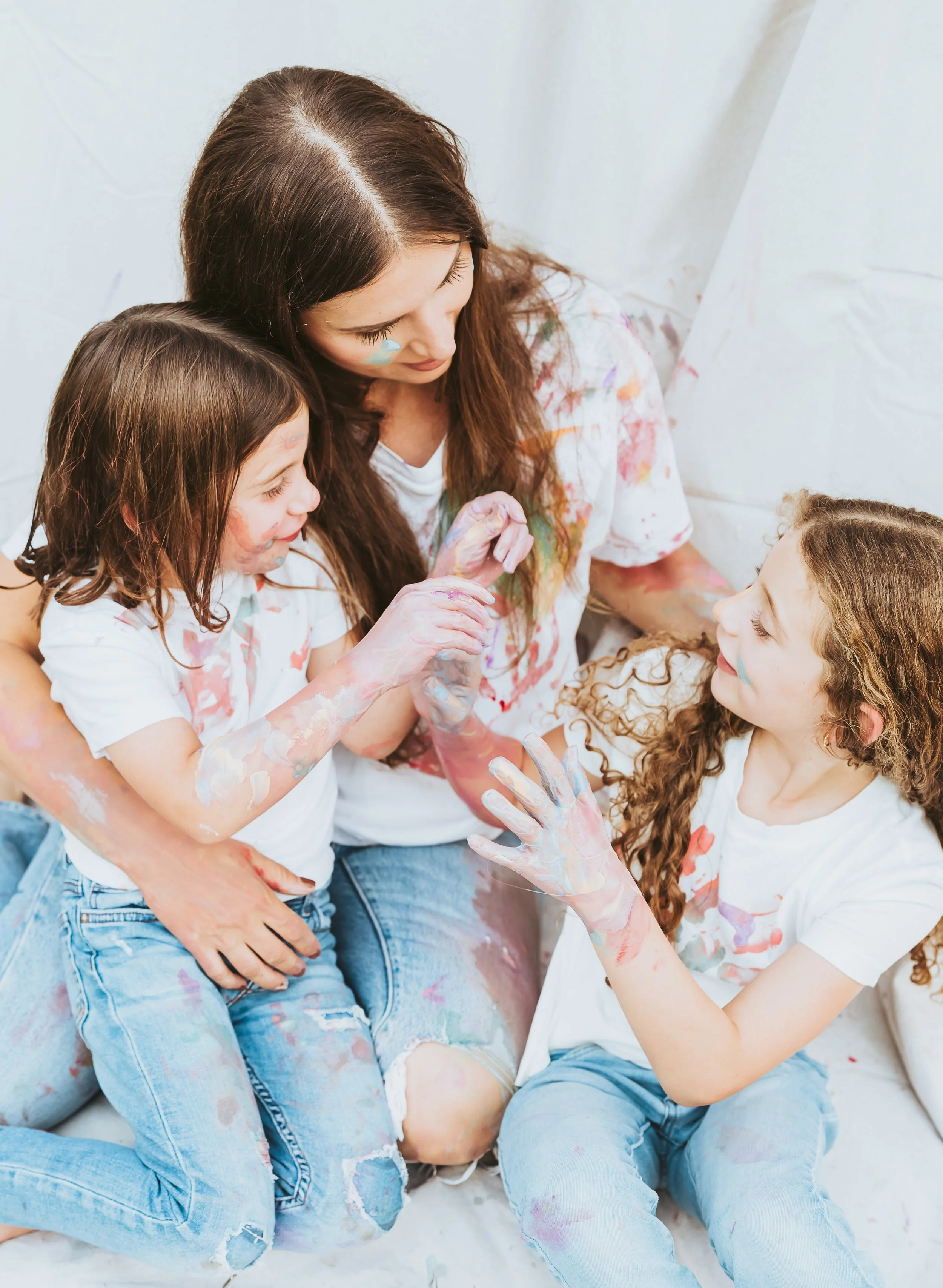 Mother daughter closeup moments during a paint mini family photography session in Alberta with playful artistic interaction.