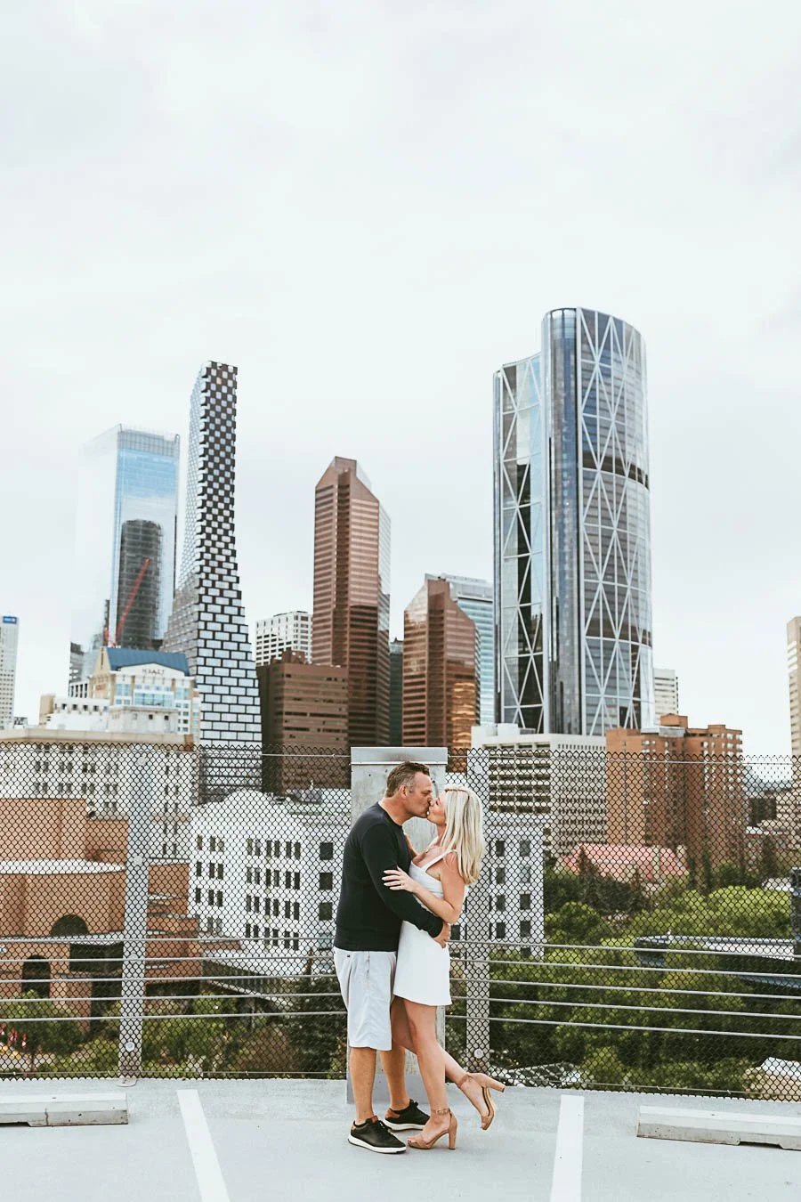 Urban engagement session in Calgary Alberta with city skyline, modern architecture, and couple walking through downtown streets