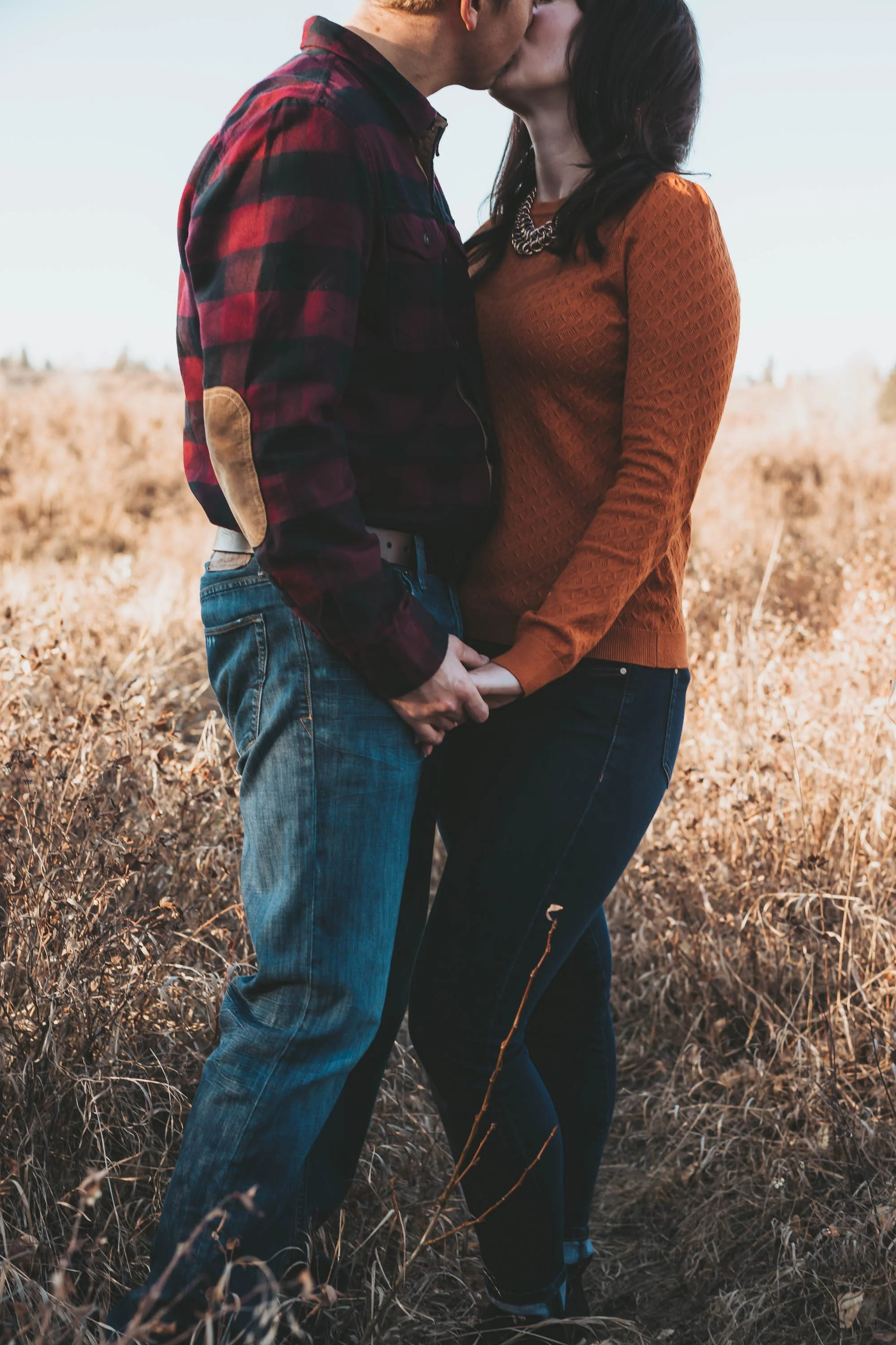 Couple kissing during sunset engagement session in Calgary local park