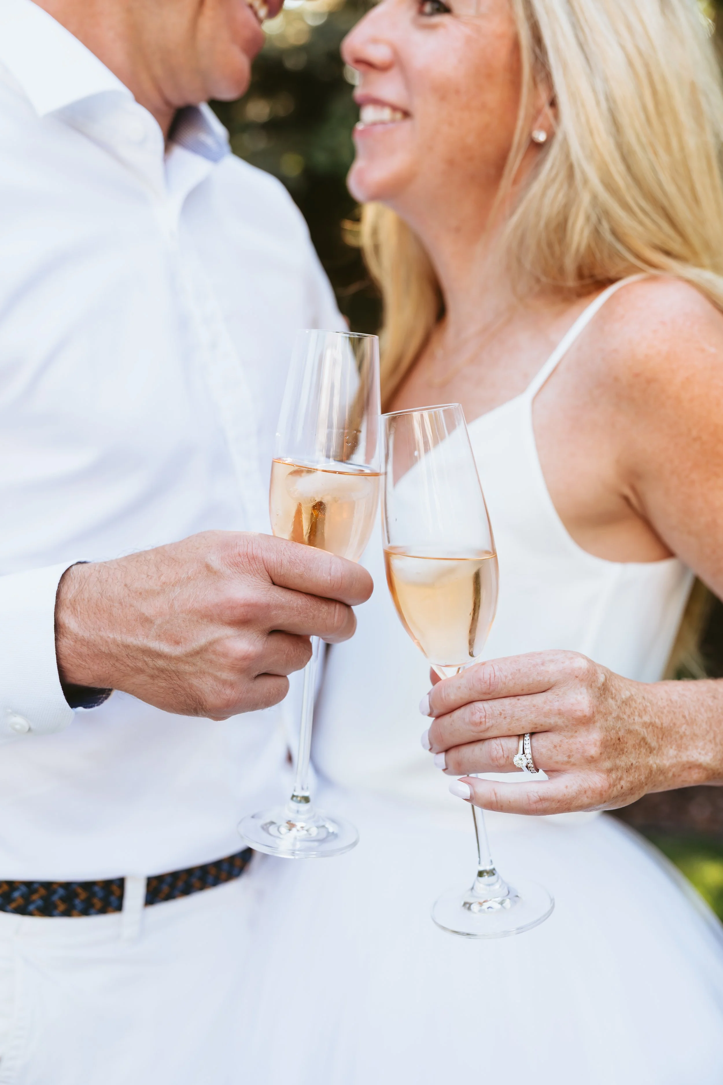Newly married couple sharing a champagne toast after an intimate backyard wedding ceremony in Calgary, Alberta.