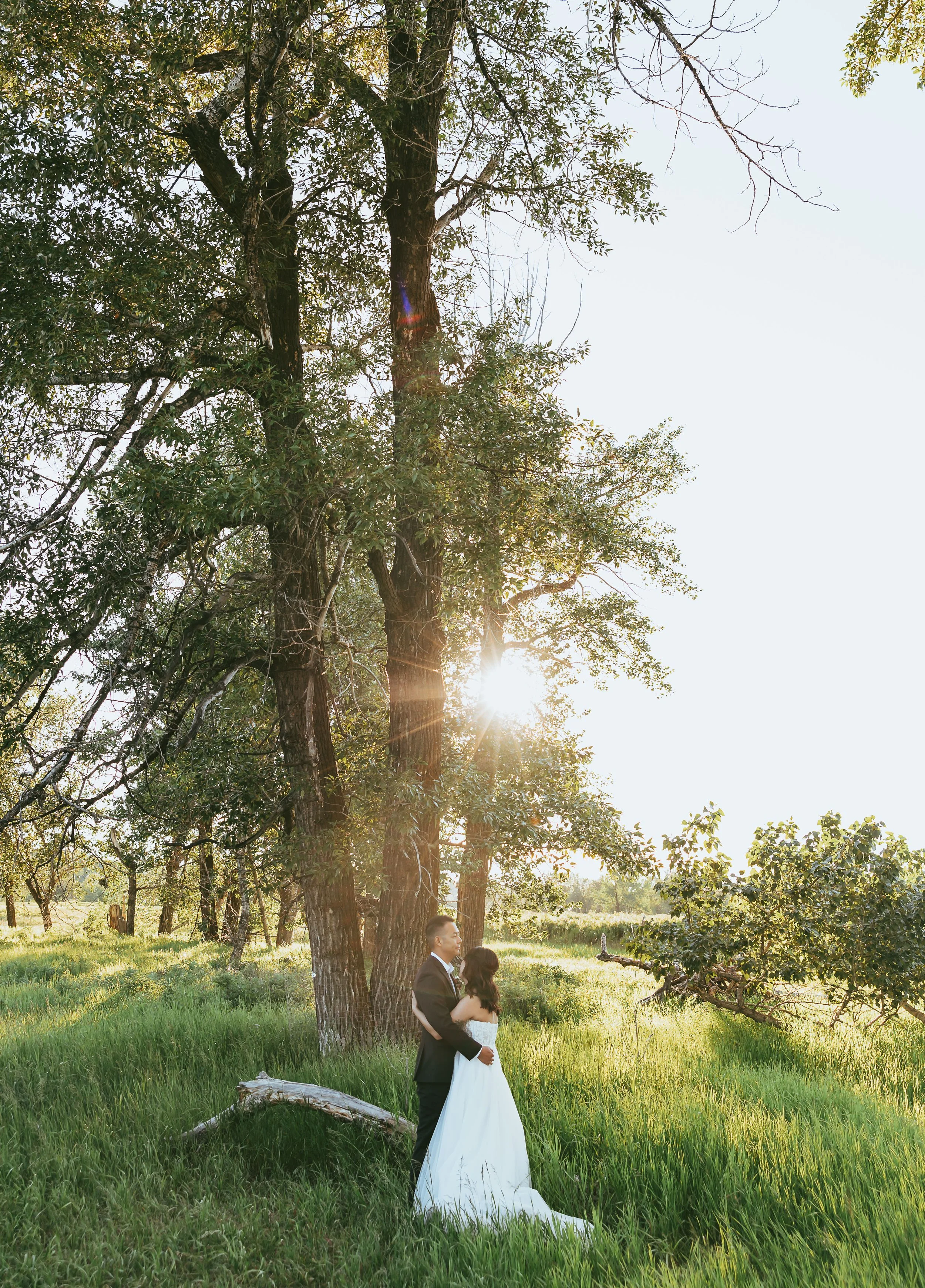 Casual elopement couple in Calgary park with natural greenery, soft light, and relaxed classic wedding attire during outdoor ceremony