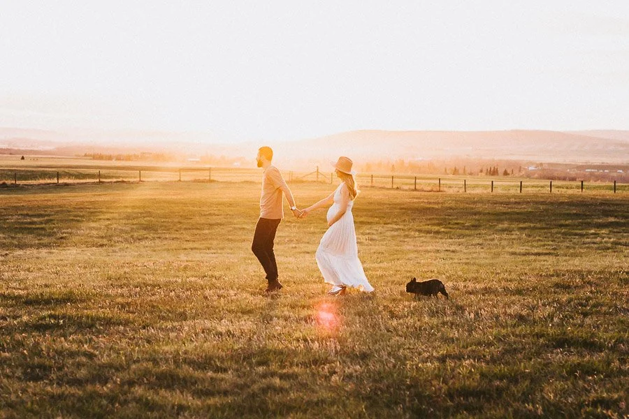 Sunset engagement session in Okotoks Alberta with couple standing in open prairie landscape and warm golden light