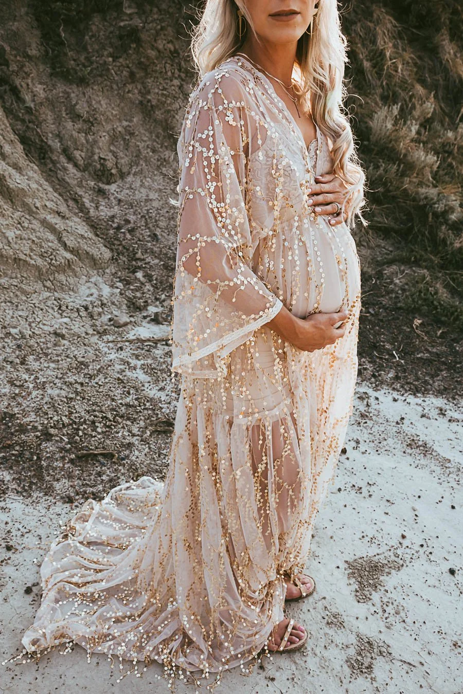 Couple during a golden hour maternity photoshoot in the Alberta Badlands near Drumheller, with soft sunlight, canyon landscape, and warm desert tones.